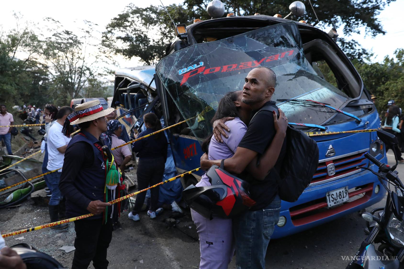 $!Parientes de víctimas se abrazan ante un autobús destruido por un dispositivo explosivo de la Autopista Panamericana en Cajibio, Colombia.