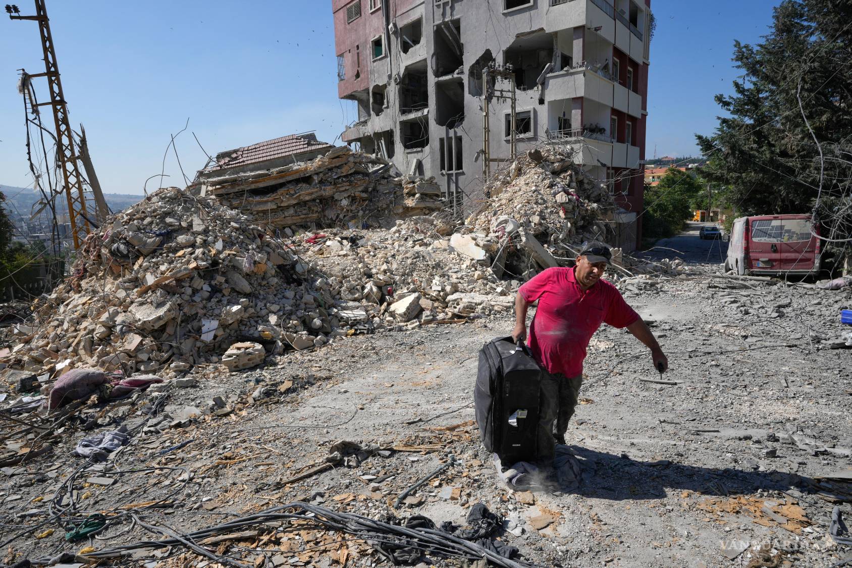 $!Un hombre que regresa a su aldea lleva una bolsa después de recoger algunas de sus pertenencias de su casa destruida en la ciudad de Nabatiyeh, Líbano.