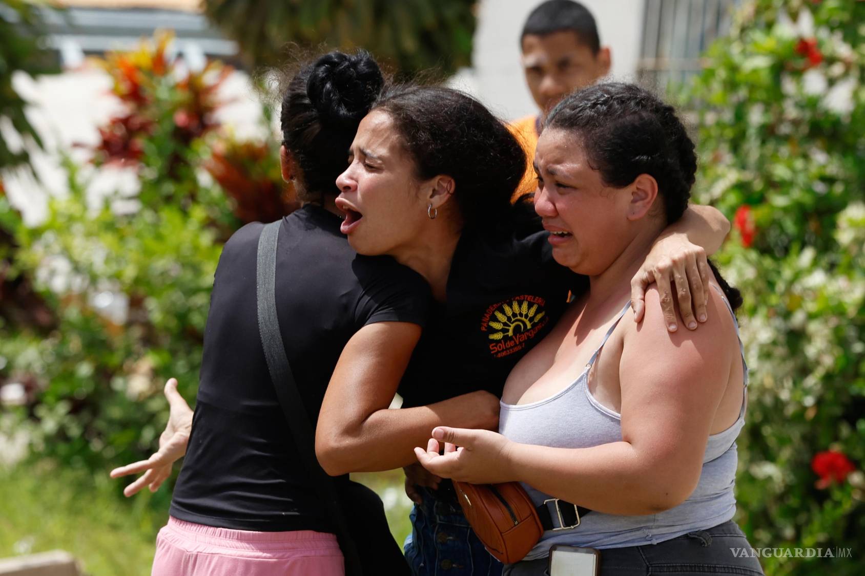 $!Vecinos consuelan a Gabriela Rojas, en el centro, mientras llora frente a su casa dañada, donde dos de sus hijos fallecieron durante los terremotos que azotaron La Guaira, Venezuela