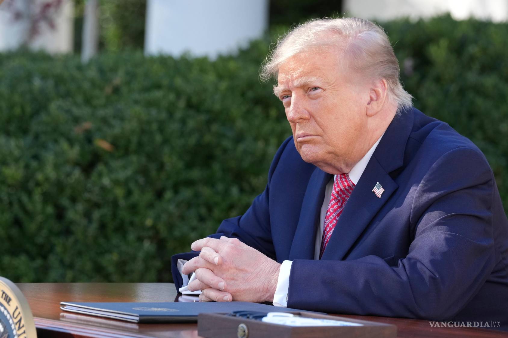 $![El presidente Donald Trump escucha mientras la primera dama Melania Trump habla durante un evento sobre las mujeres]