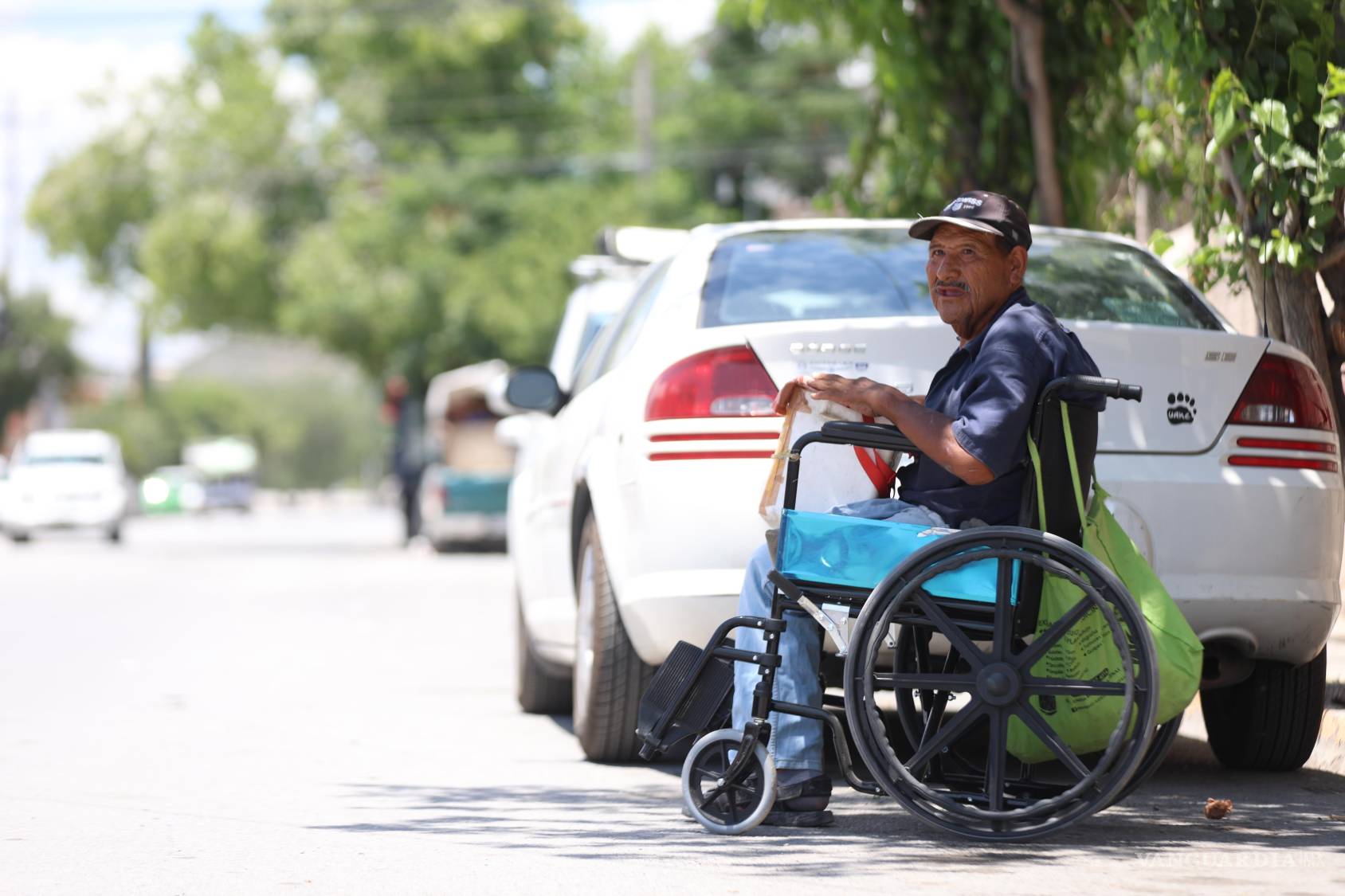 $!Anastasio Rodríguez recorre a diario las calles en su silla de ruedas para vender bolis; esquivar autos estacionados en las banquetas es parte de su rutina.