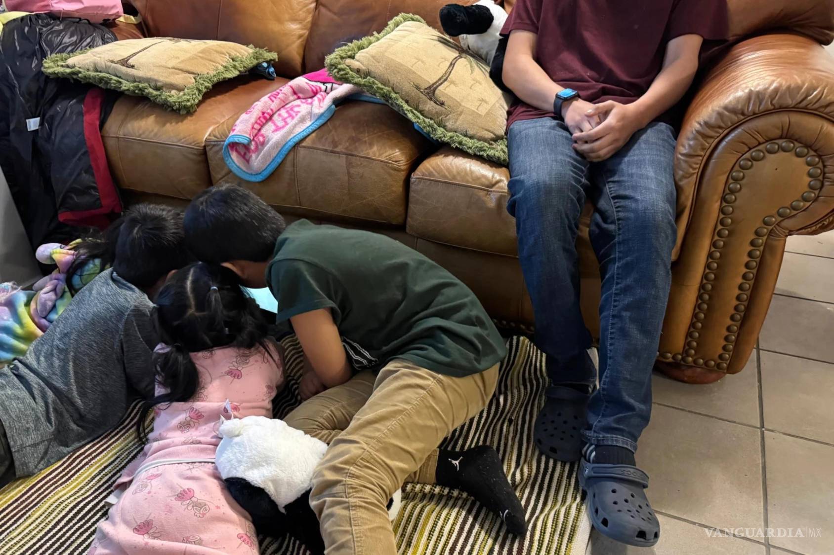 $!Un niño en una casa de acogida en Minneapolis con sus hermanos menores y su sobrina juegan en el suelo tras haber huido de su hogar porque eran buscados por agentes federales de inmigración.