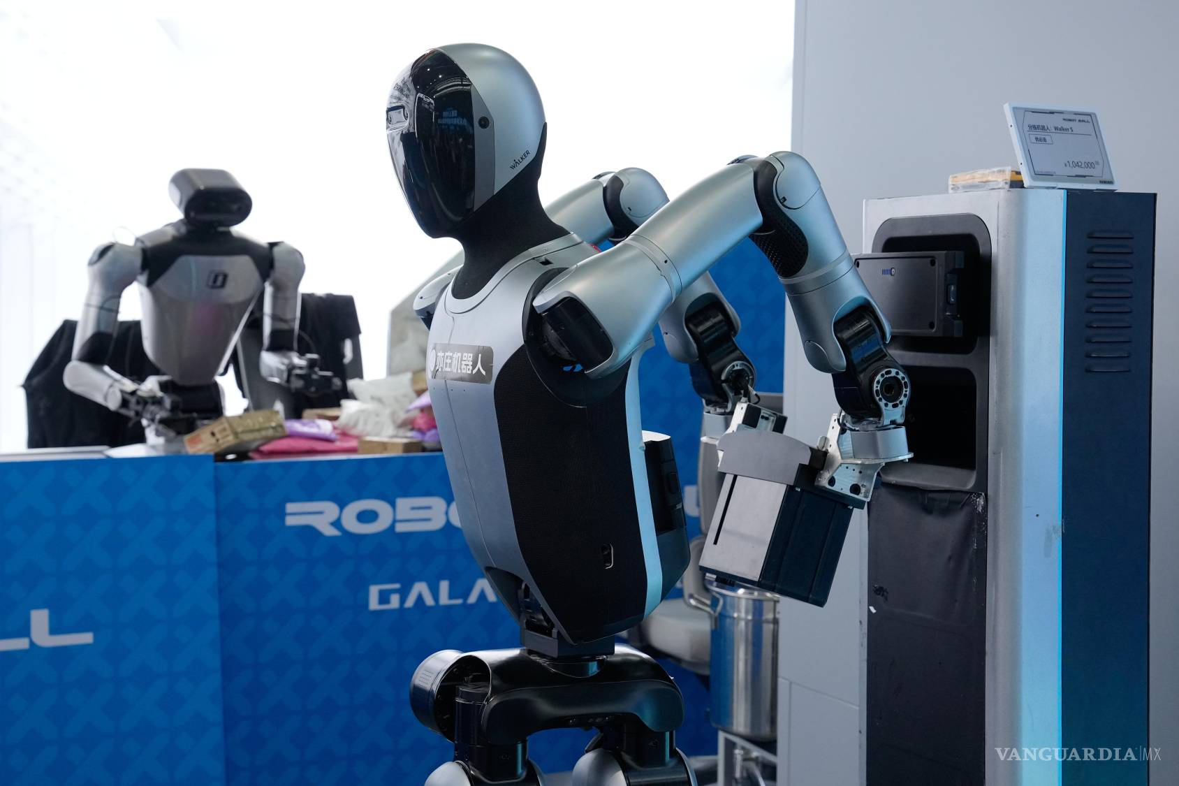 $!Un robot reemplaza una batería por sí solo mientras otro clasifica paquetes en el Centro de Innovación de Robótica Humanoide de Beijing.