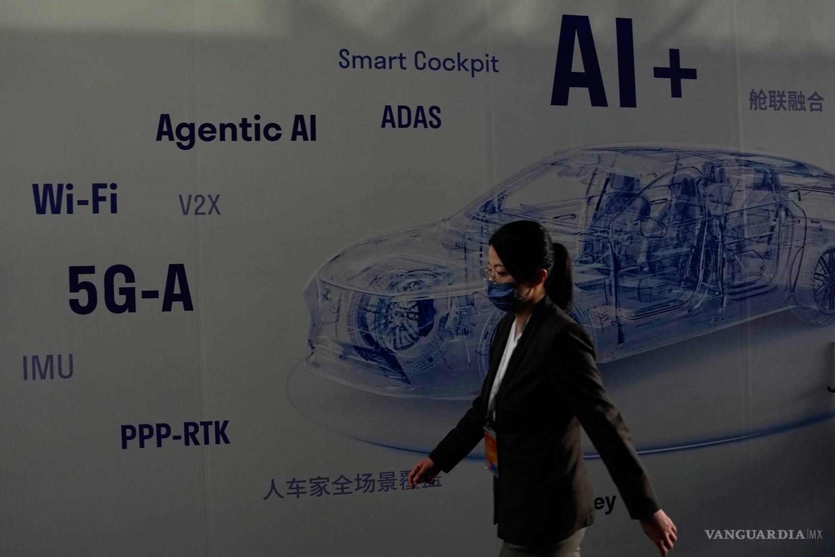 $!Una mujer pasa junto a un panel informativo que muestra un vehículo eléctrico impulsado por inteligencia artificial (IA) en el Auto China 2026, en Pekín.