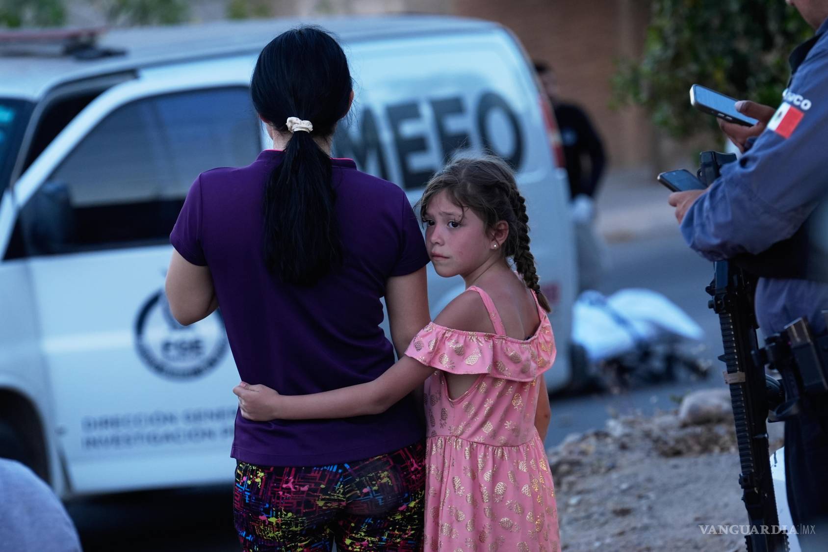 $!Familiares de una víctima de un ataque armado mortal observan mientras los peritos forenses investigan la escena del crimen en Culiacán el 26 de abril de 2026.