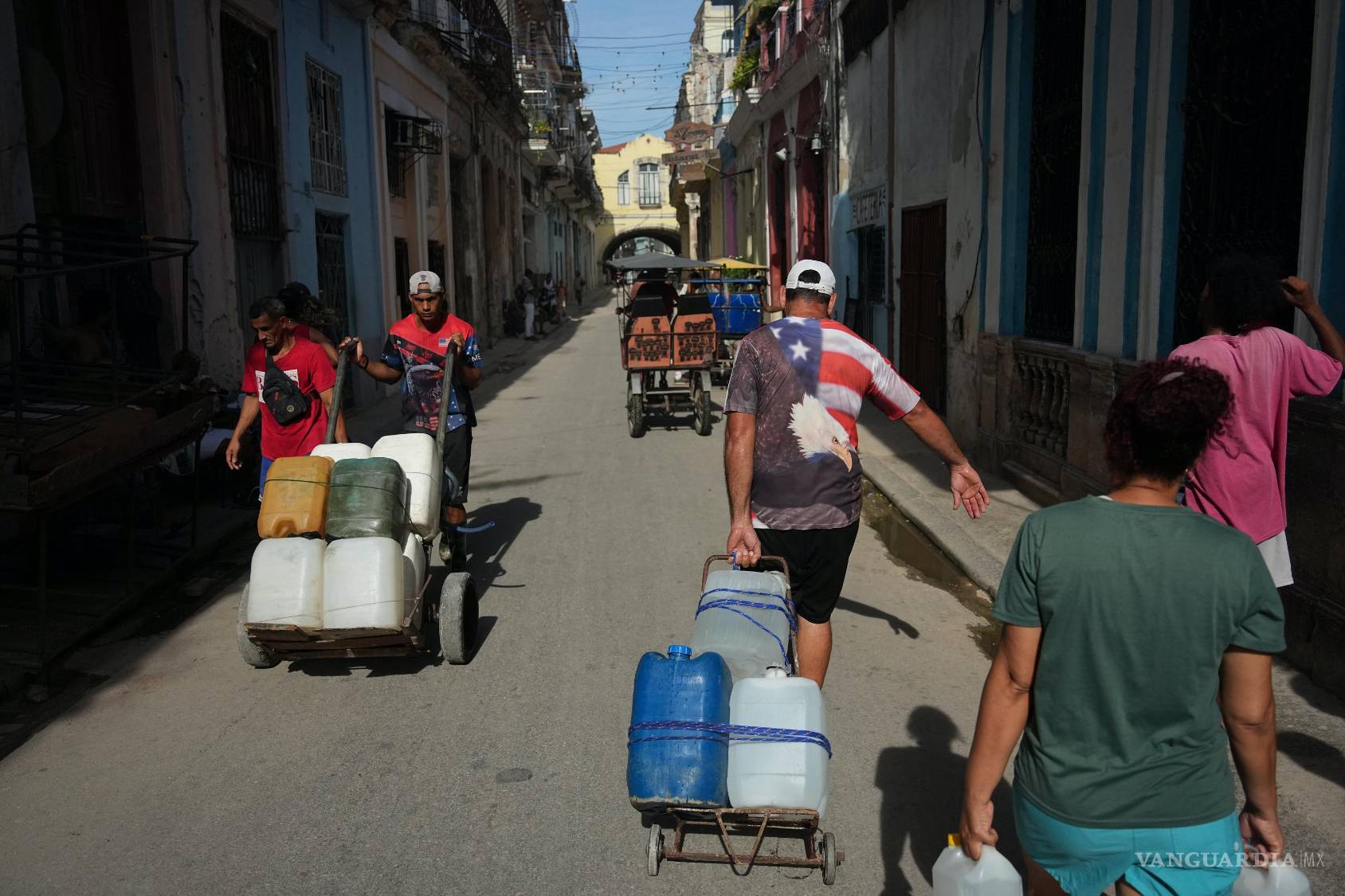 $!Varias personas transportan agua durante un apagón en La Habana, Cuba, el lunes 3 de agosto de 2026.