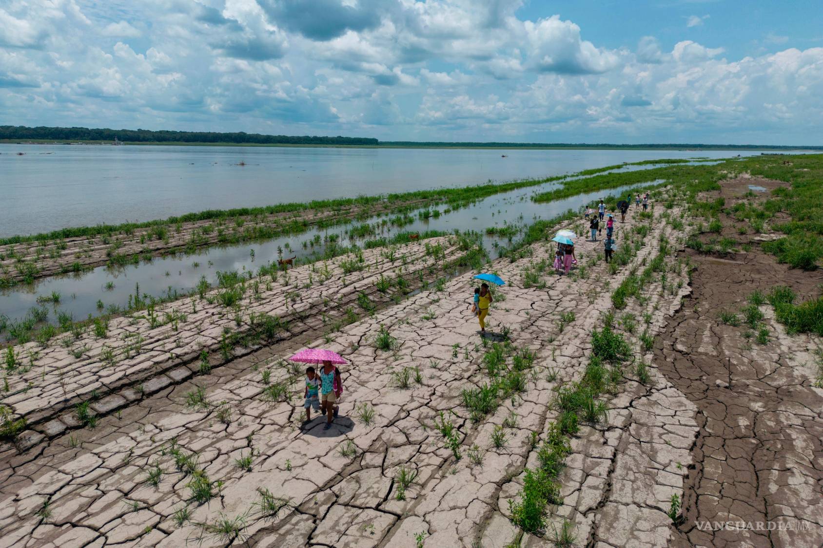 $!Personas caminan por una zona del río Amazonas que muestra signos de sequía en Santa Sofía, en las afueras de Leticia, Colombia, el 20 de octubre de 2024.