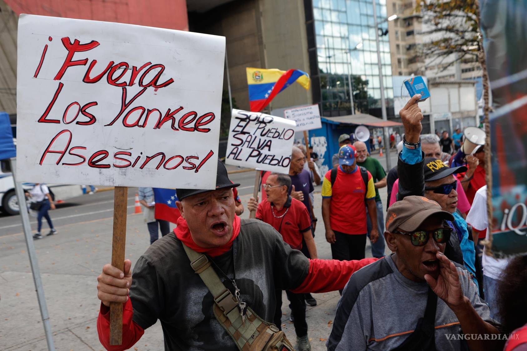 $!Varias personas sostienen carteles en una protesta en Caracas en oposición al acuerdo de Donald Trump que le otorga a EU participación en las reservas petroleras de Venezuela.