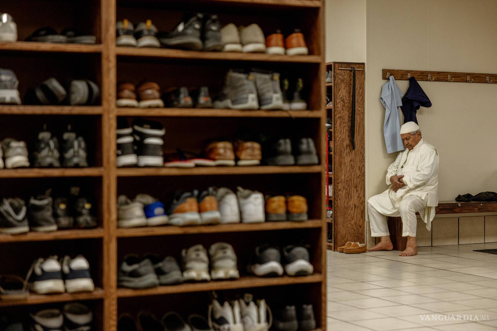 $!Un hombre reza en la Islamic Society of Tulsa en Tulsa, Oklahoma. A la izquierda se encuentran repisas para los zapatos de los asistentes.