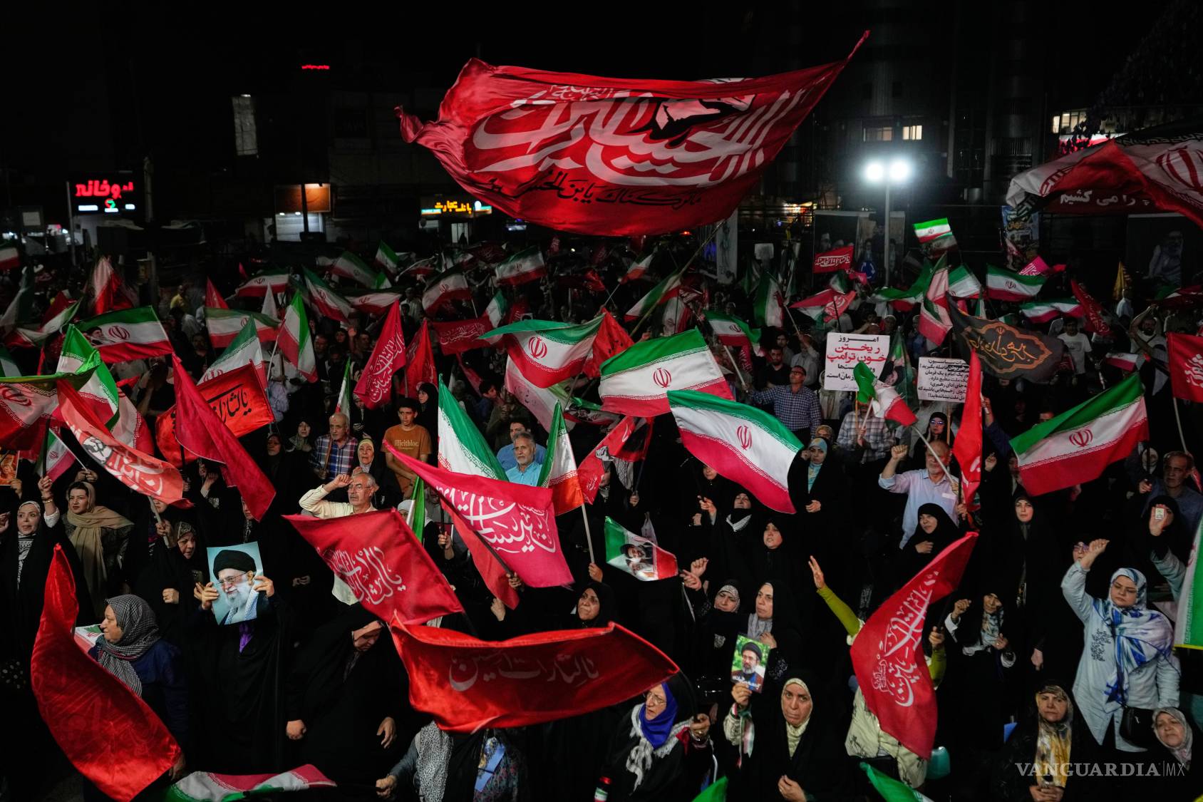 $!Manifestantes iraníes progubernamentales ondean banderas durante una concentración en una plaza, el miércoles 26 de agosto de 2026, en Teherán.
