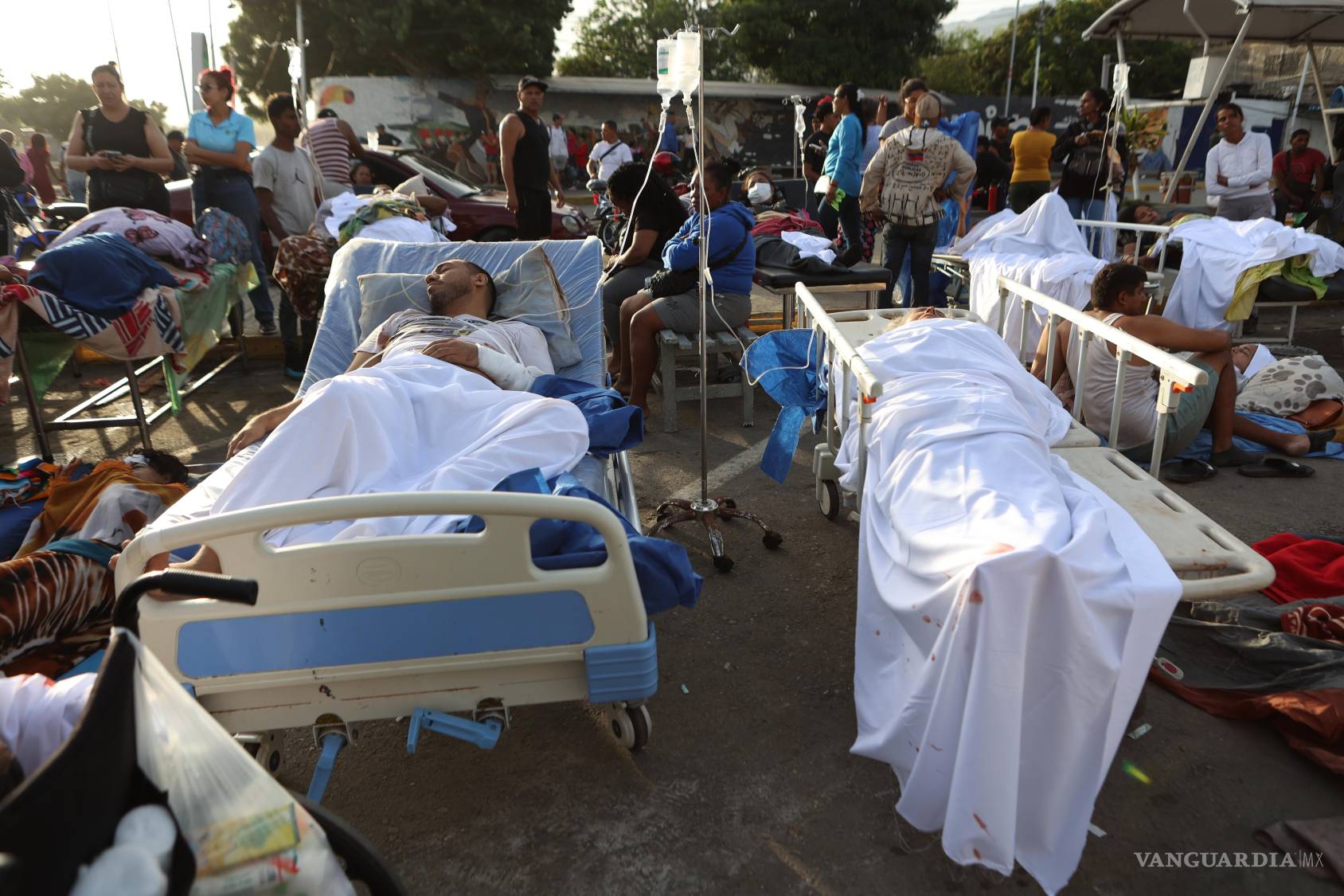 $!Pacientes yacen fuera de un hospital evacuado tras sufrir daños por un terremoto en Catia La Mar, Venezuela.