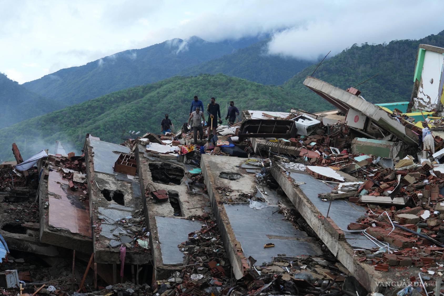 $!Residentes buscan entre los escombros de un edificio que se derrumbó durante los terremotos en La Guaira, Venezuela.