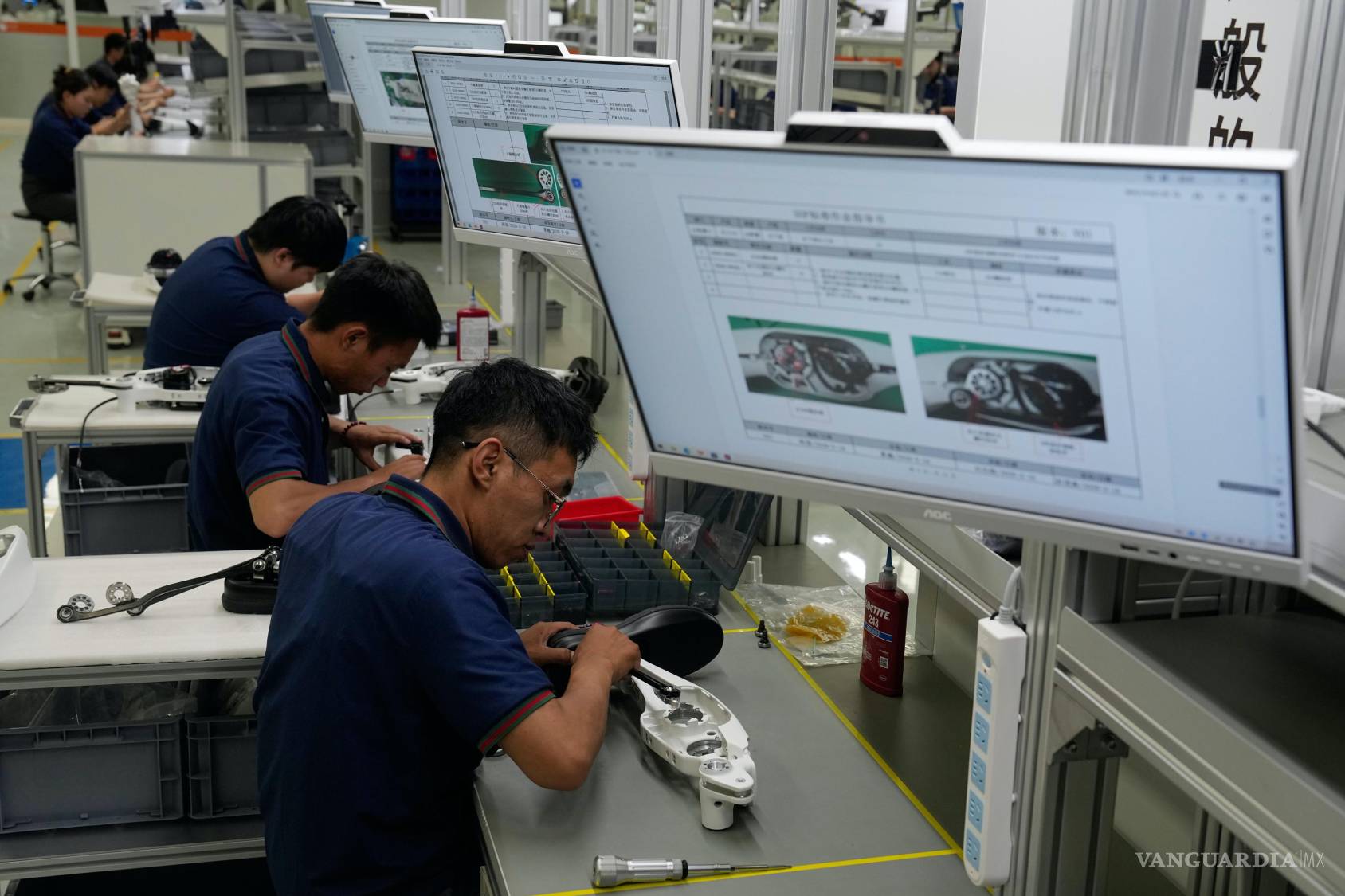 $!Trabajadores ensamblan componentes de las piernas de un robot en la Superfábrica de Inteligencia Artificial Incorporada de LY iTech en Pekín.
