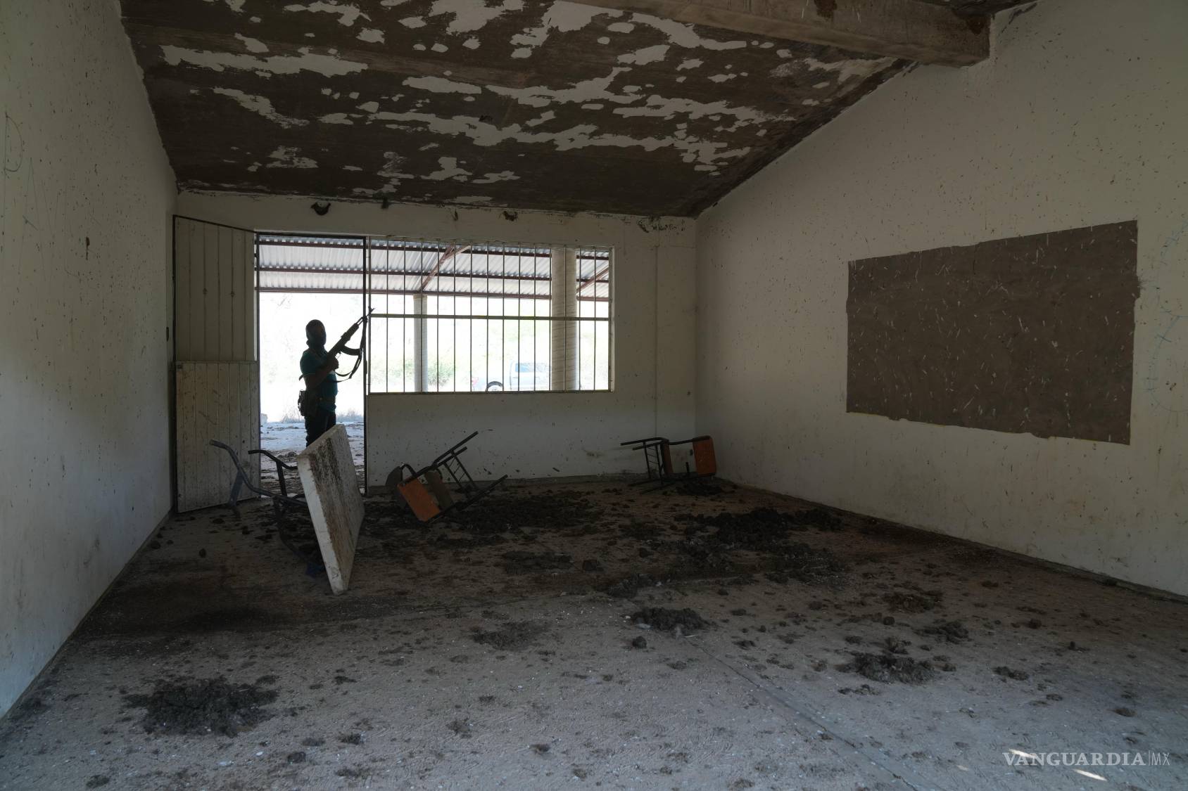 $!Un miembro de un grupo local de autodefensa formado por residentes en respuesta a la violencia de los cárteles vigila una escuela cerrada en Guajes de Ayala.