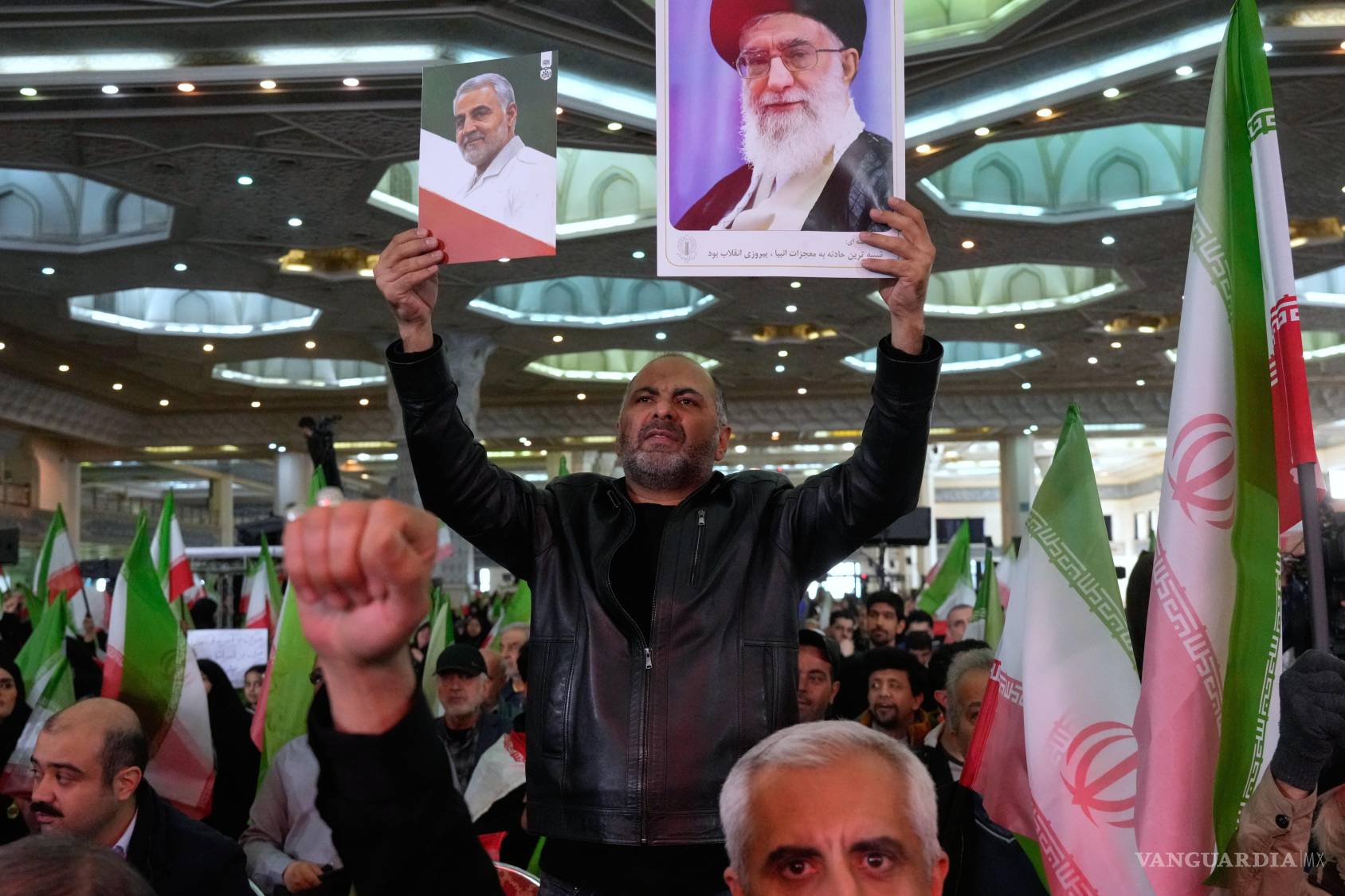 $!Un hombre sostiene imágenes del ayatolá Alí Jamenei (D), y del difunto del general Qassem Soleimani, quien murió en un ataque stadounidenses en Irak en 2020