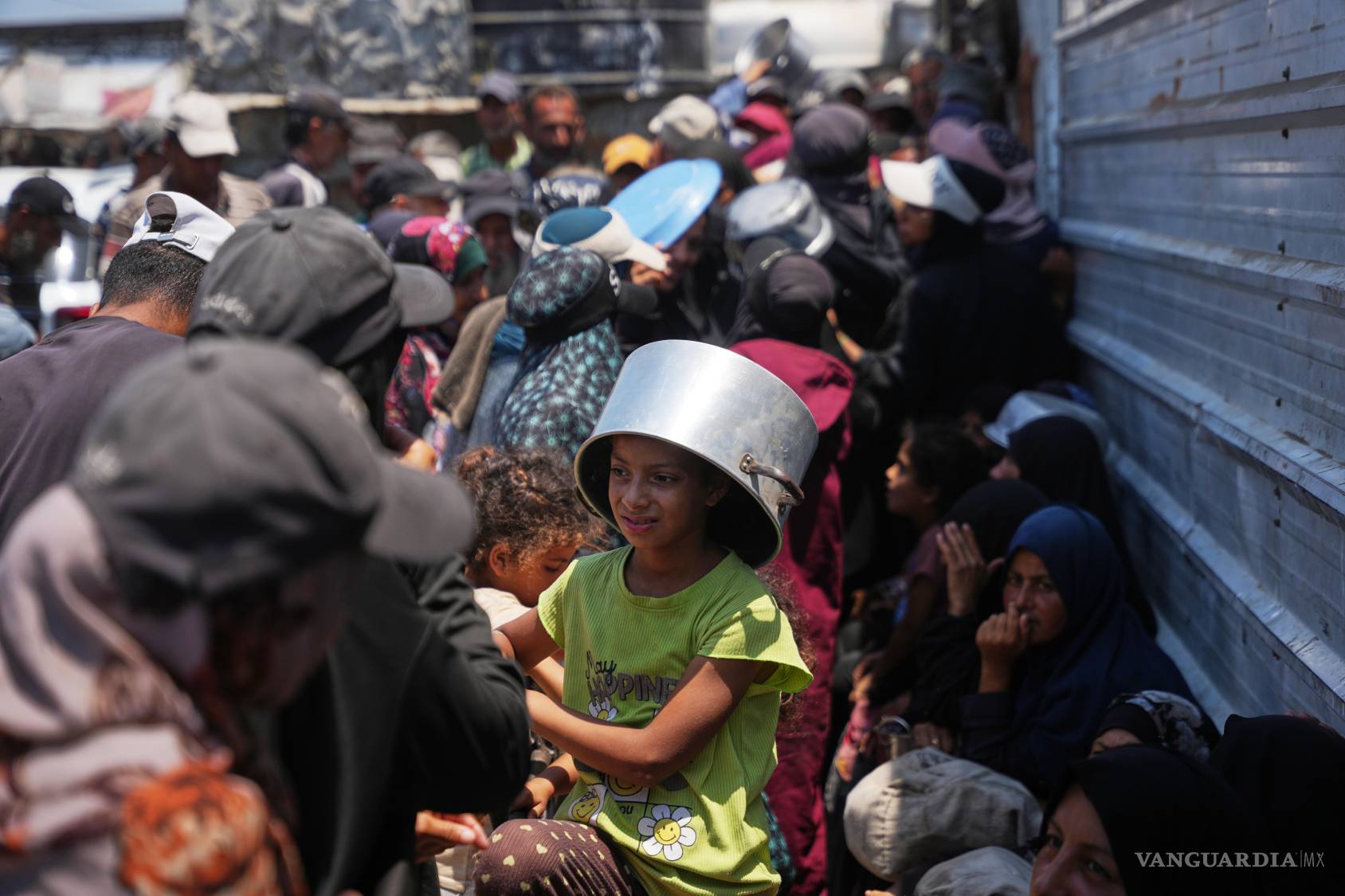 $!Palestinos desplazados forman una fila para recibir alimentos donados en una cocina comunitaria en Jan Yunis, en el sur de la Franja de Gaza.