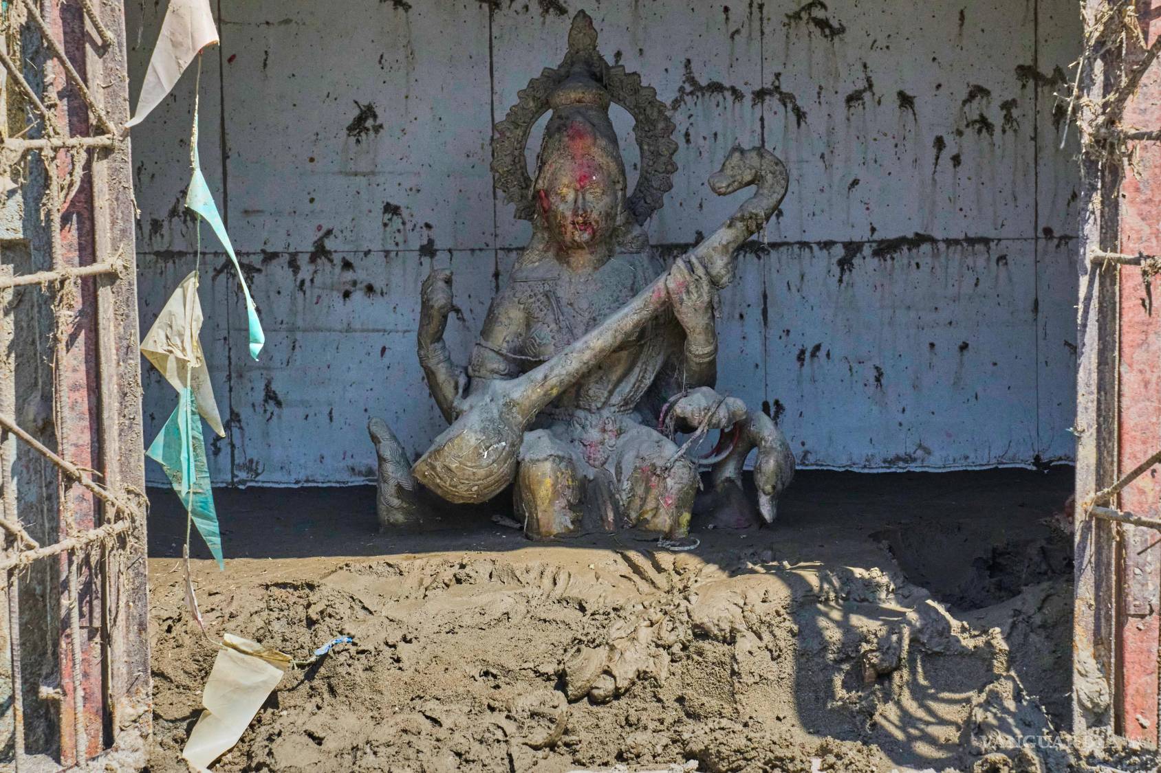 $!El barro arrastrado por las recientes inundaciones repentinas rodea una estatua de Saraswati, la diosa hindú del conocimiento, situada a la entrada de la escuela Shree Bagheswori Madhyamik en Galchhi, distrito de Dhading, Nepal, el domingo 30 de agosto de 2026.