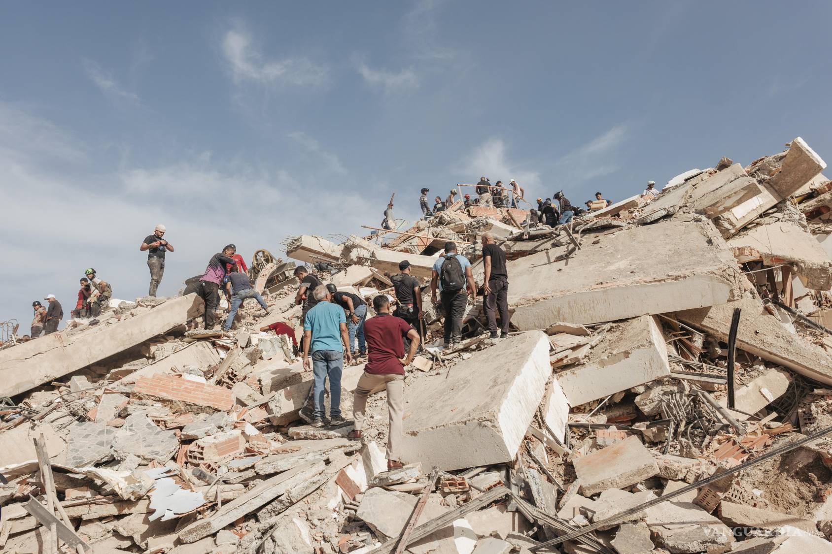 $!Personas buscan sobrevivientes entre los escombros de un edificio residencial que se derrumbó durante los terremotos en La Guaira, Venezuela.