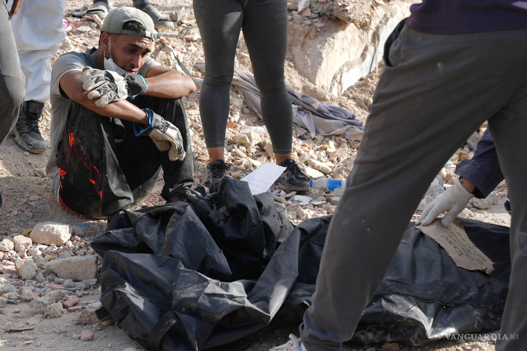 $!Leonel Gutiérrez se sienta junto a los restos de su hijo, Dylan Gutiérrez, y su madre del niño, a quienes rescataron de entre los escombros en La Guaira.