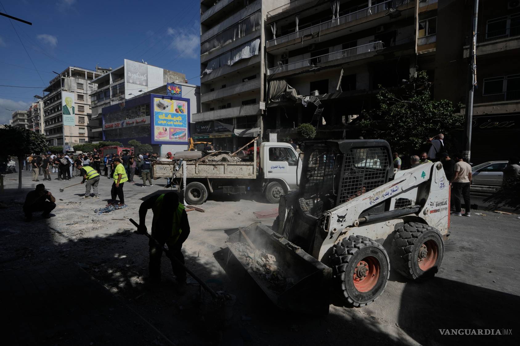 $!Trabajadores retiran escombros cerca de un edificio de apartamentos dañado por un ataque aéreo israelí en Dahiyeh, en los suburbios del sur de Beirut, Líbano.
