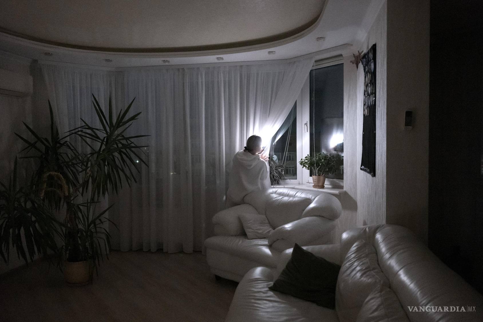 $!Yuliia Kulyk mira por la ventana de su apartamento a oscuras durante un corte de electricidad en Kiev, Ucrania, el 7 de octubre de 2026. Moscú no está ganando en el campo de batalla; en cambio, aprovecha la oportunidad para infligir un inmenso sufrimiento humano en las ciudades ucranianas. (Jędrzej Nowicki/The New York Times)