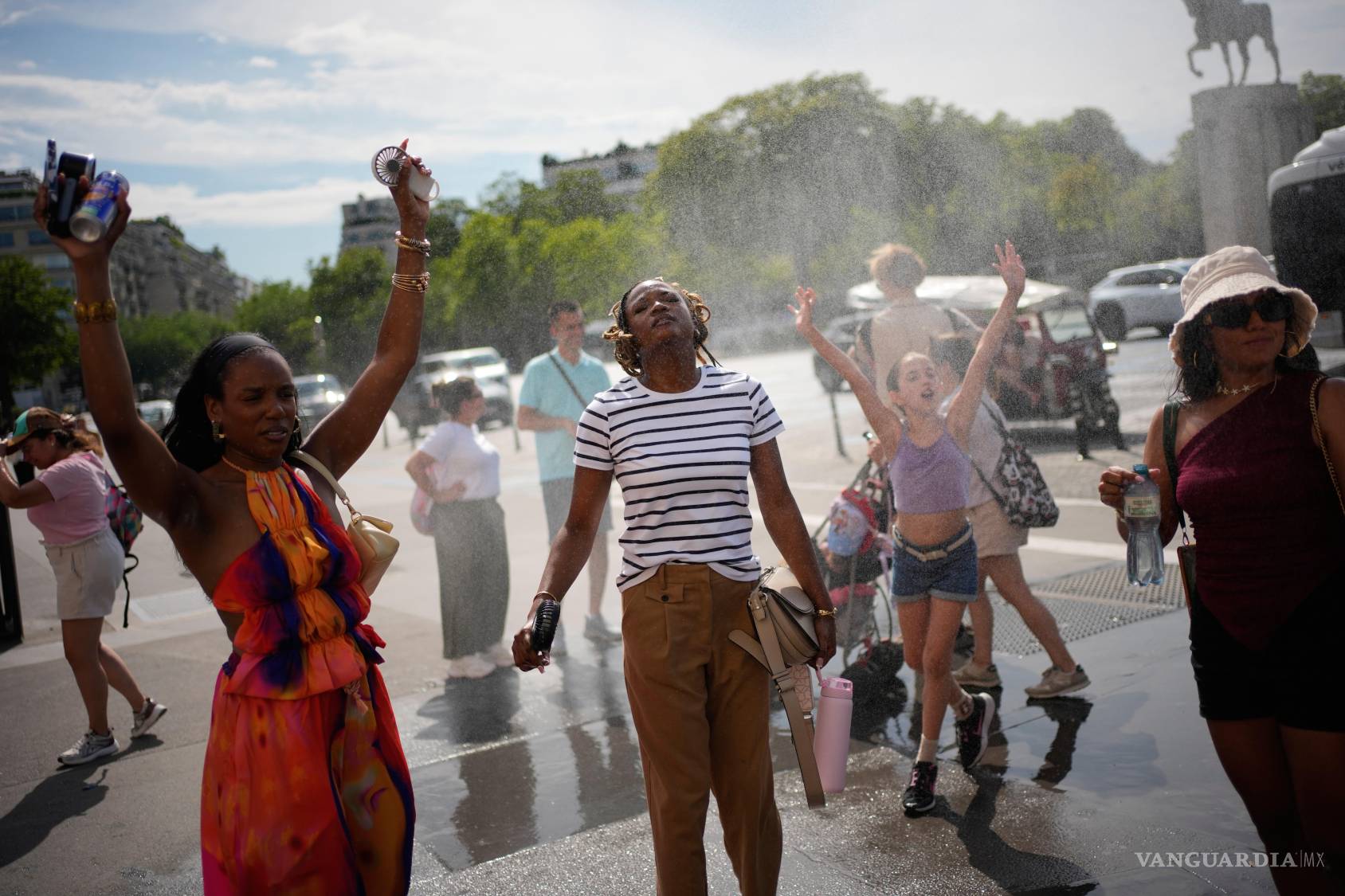 $!Personas se refrescan en una fuente pública de agua en París, el 26 de junio de 2026.
