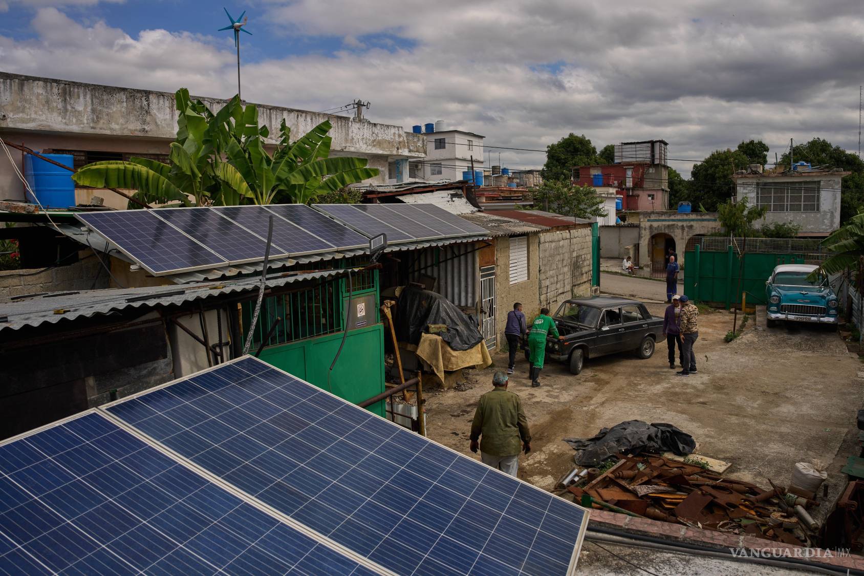 $!Paneles solares en la casa de Félix José Morfi mientras mecánicos empujan su carro Lada en Regla, en la provincia de La Habana, Cuba.