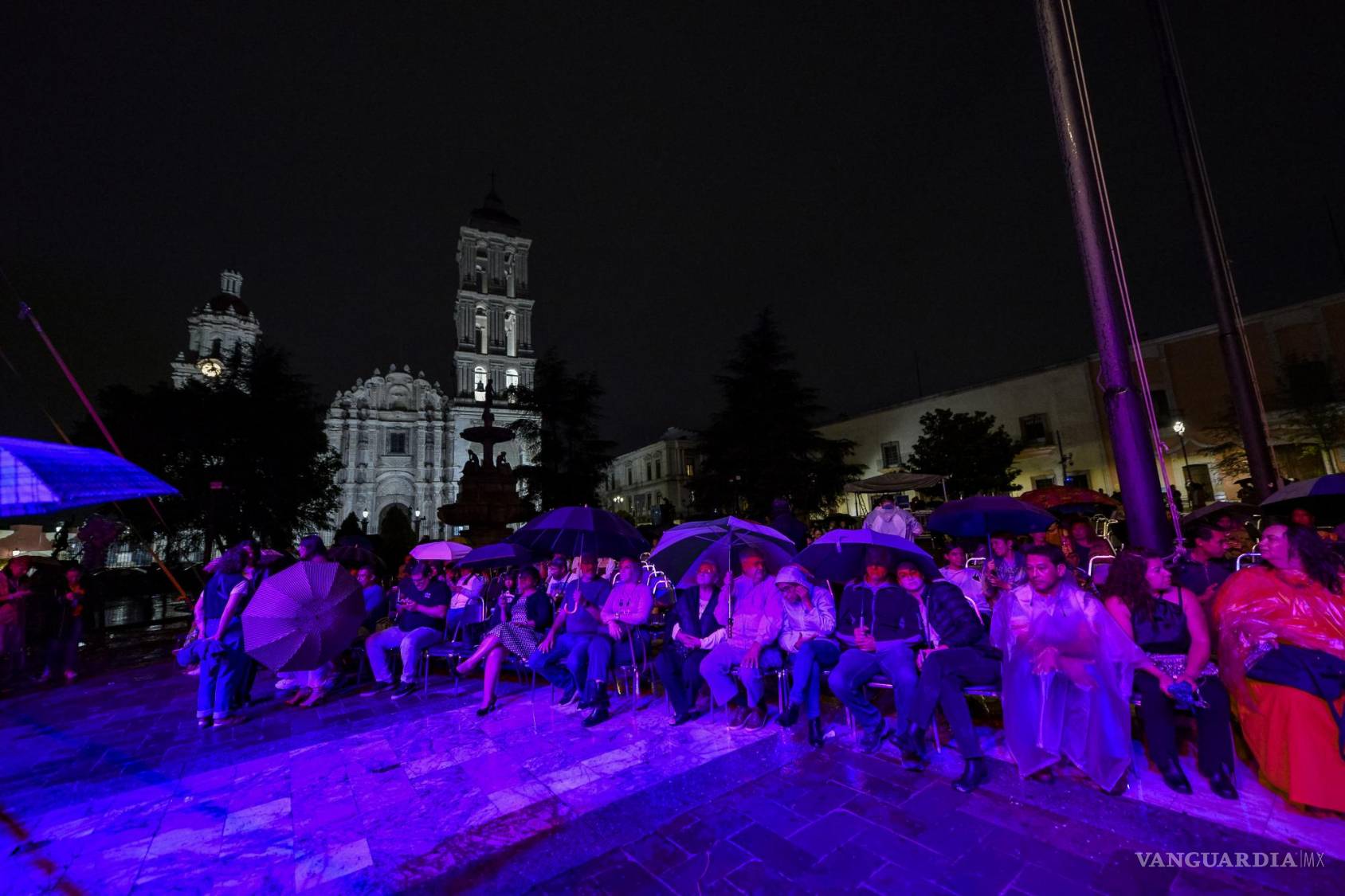 $!Algunos asistentes optaron por portar paraguas y rompe vientos para mitigar el impacto de la lluvia.