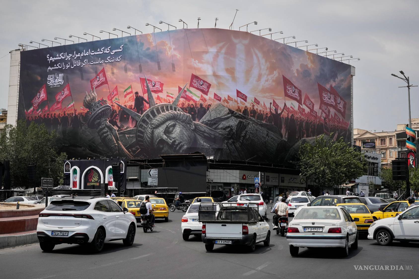 $!Una valla publicitaria que muestra una Estatua de la Libertad caída y multitudes portando banderas iraníes y chiíes en la Plaza de la Revolución en Teherán, Irán.