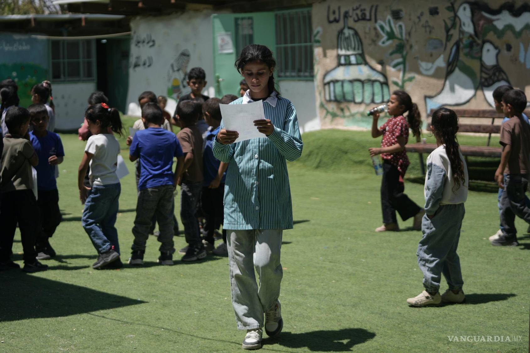 $!Estudiantes palestinos reciben sus boletines de calificaciones de fin de año en una escuela en la aldea beduina de Khan al-Ahmar, en Cisjordania.