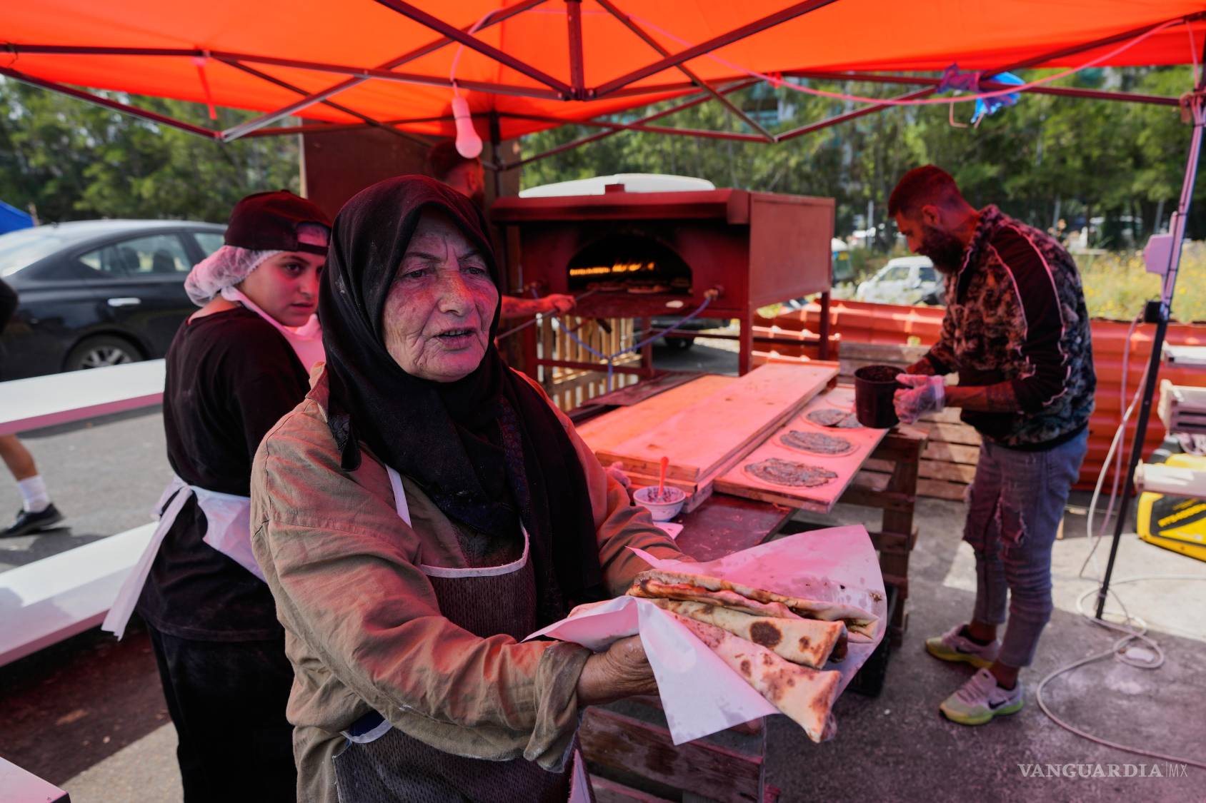 $!Soubhiye Zeiter distribuye mana’eesh, un popular desayuno libanés a base de pan plano con tomillo, en una pequeña panadería ubicada en un asentamiento.