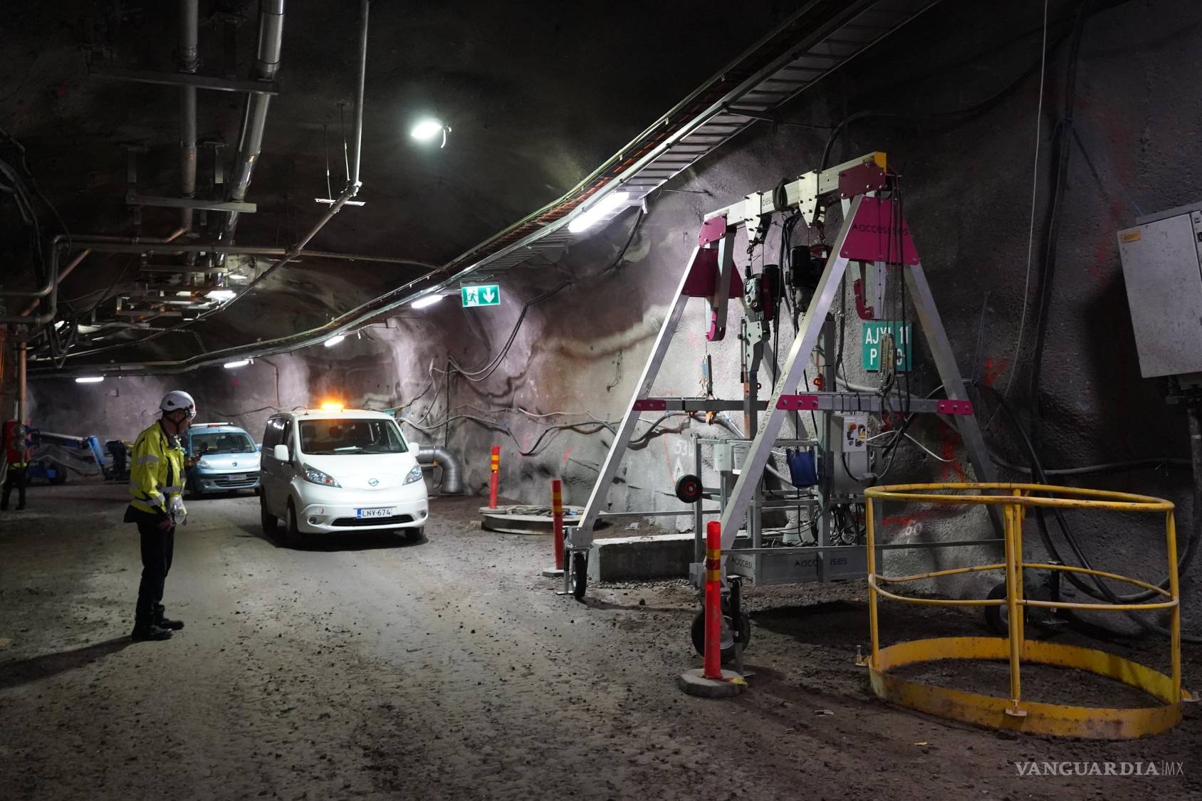 $!Un trabajador de Posiva permanece junto a varios vehículos dentro de un túnel en el depósito de residuos nucleares de Onkalo, en la isla de Olkiluoto, Finlandia.