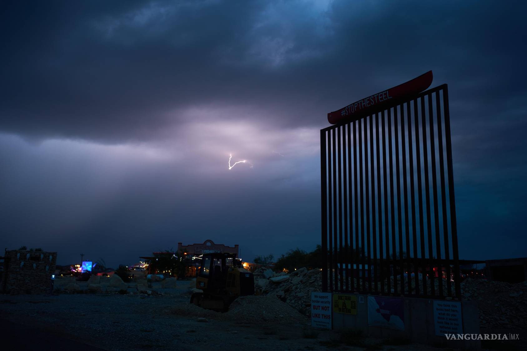 $!Un relámpago ilumina el cielo tras un modelo del muro fronterizo en protesta contra las barreras propuestas en la frontera en Terlingua, Texas.