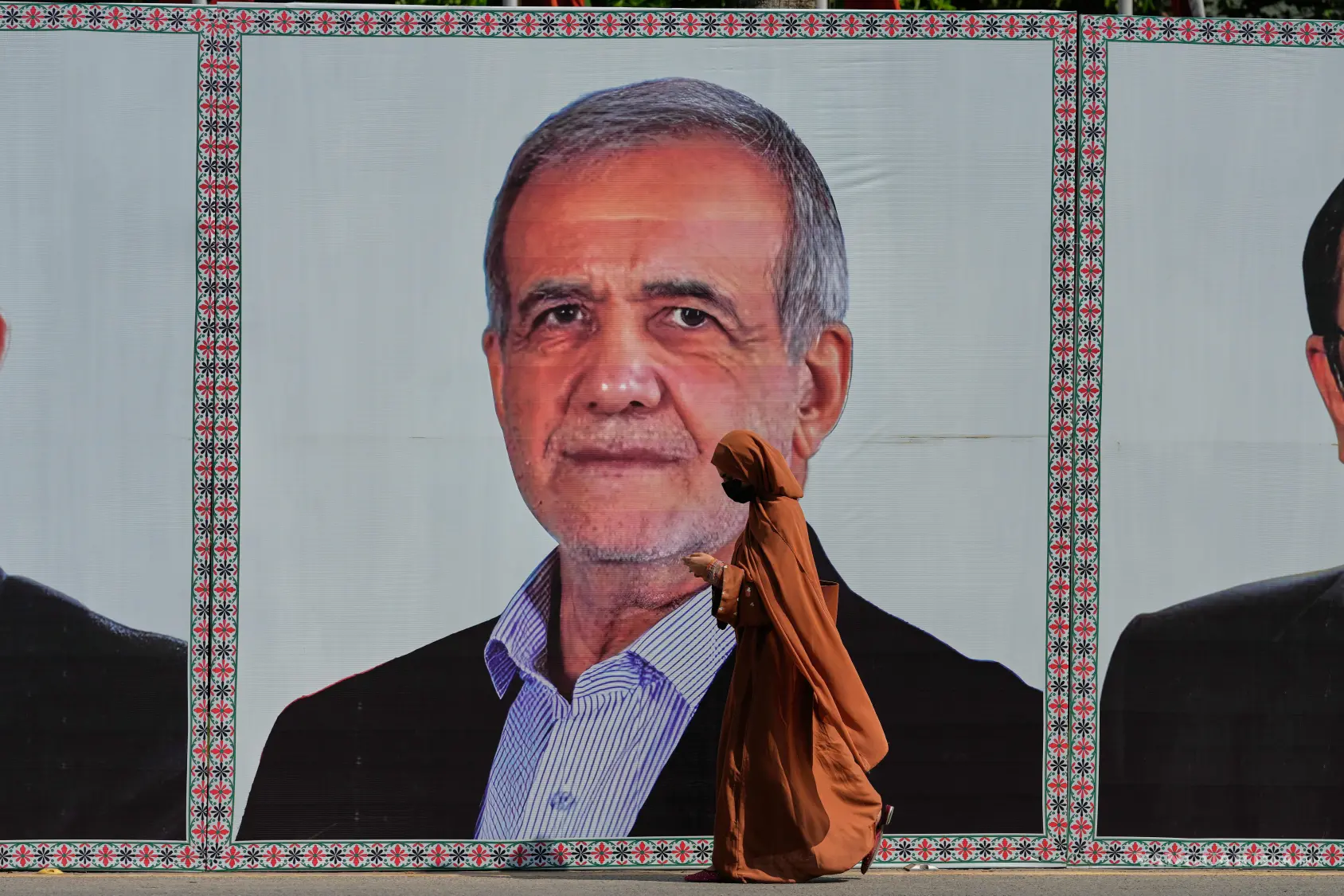 $!Una mujer pasa frente a un anuncio con la imagen del presidente de Irán, Masoud Pezeshkian, el martes 23 de junio de 2026, en Islamabad, Pakistán.