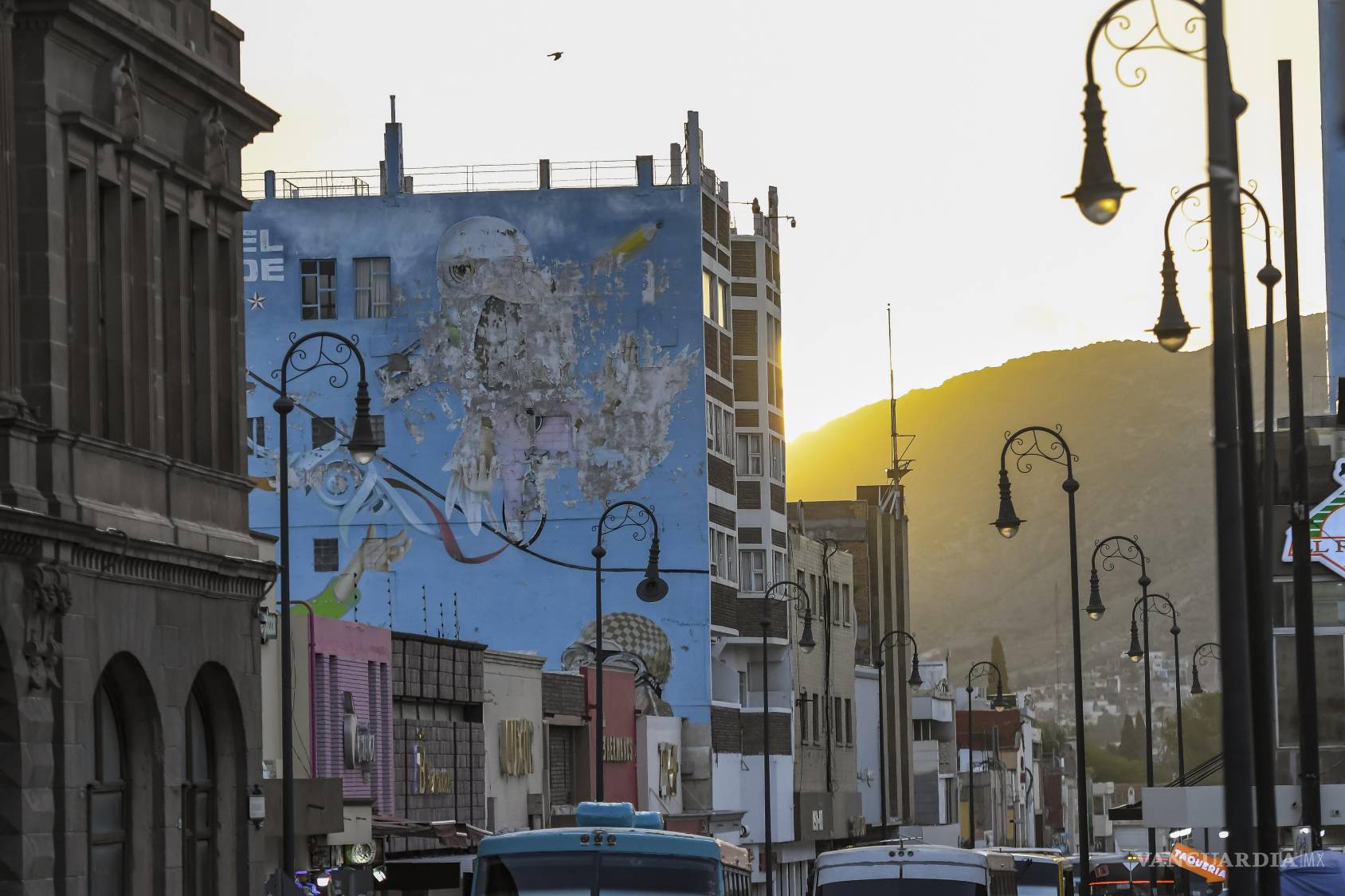 $!La calle Aldama, vista de oriente a poniente, reúne edificios de distintas alturas, anuncios, luminarias y el perfil de la sierra al fondo. Entre el tránsito cotidiano, la ciudad todavía ofrece perspectivas que sólo aparecen cuando se mira más allá de la banqueta.