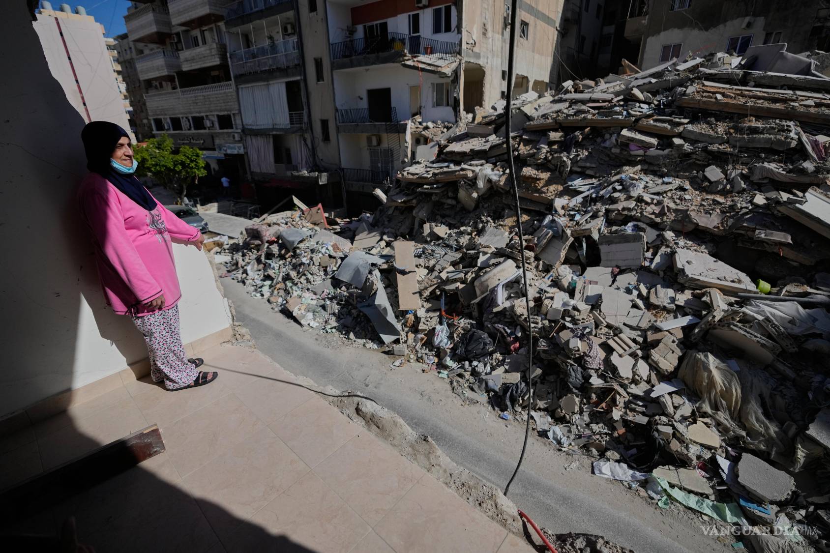 $!Em Ali Khodor, de 75 años, mira a través de su apartamento dañado hacia un edificio destruido alcanzado hace unas semanas por un ataque aéreo israelí.