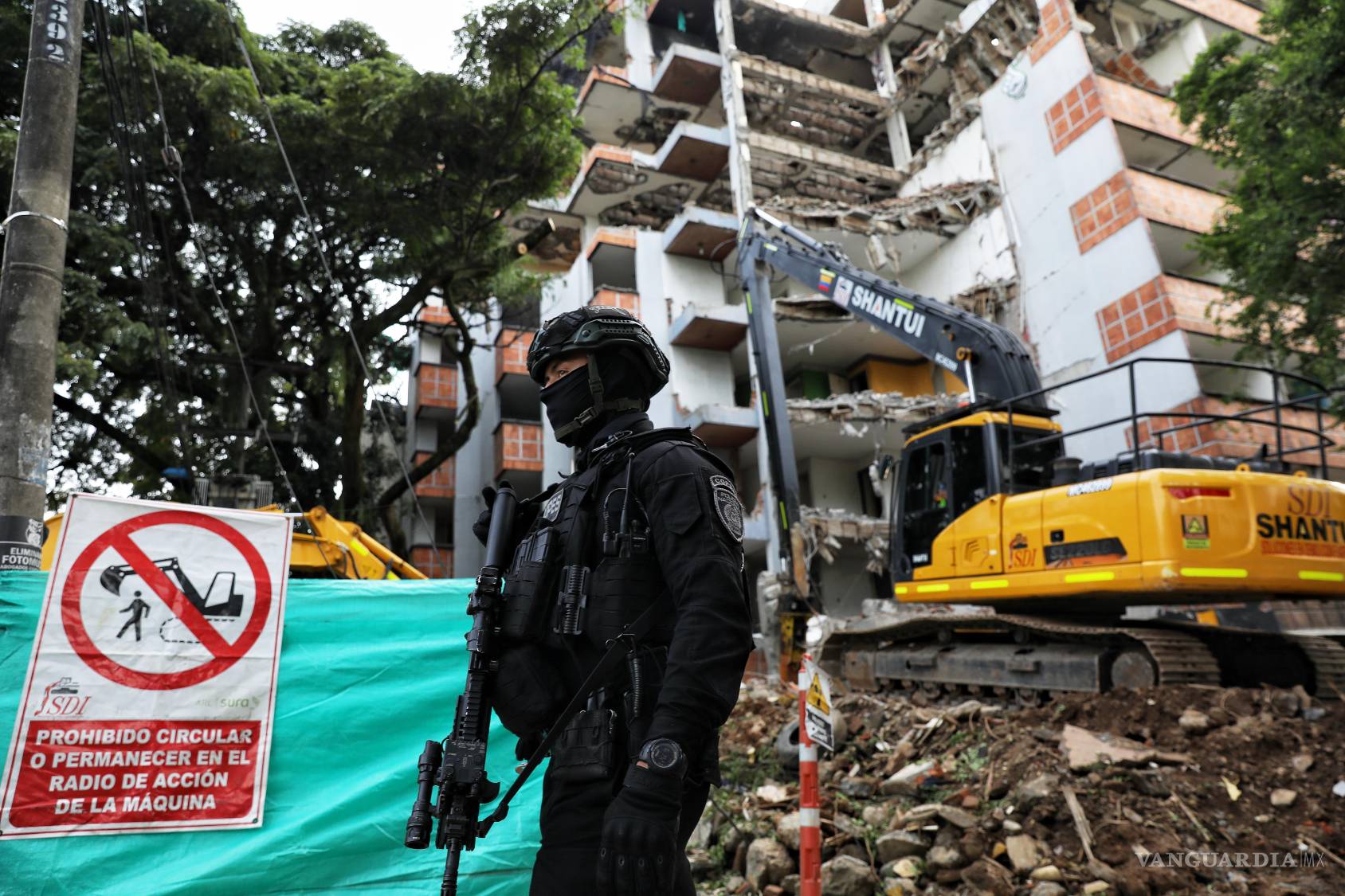$!Un agente de policía vigila la demolición de un edificio que perteneció al fallecido narcotraficante Elmer Herrera en Cali, Colombia.