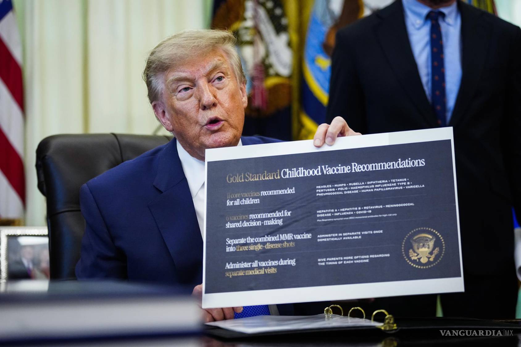 $!El presidente de los Estados Unidos, Donald Trump, muestra las recomendaciones sobre vacunas infantiles en el Despacho Oval de la Casa Blanca en Washington.