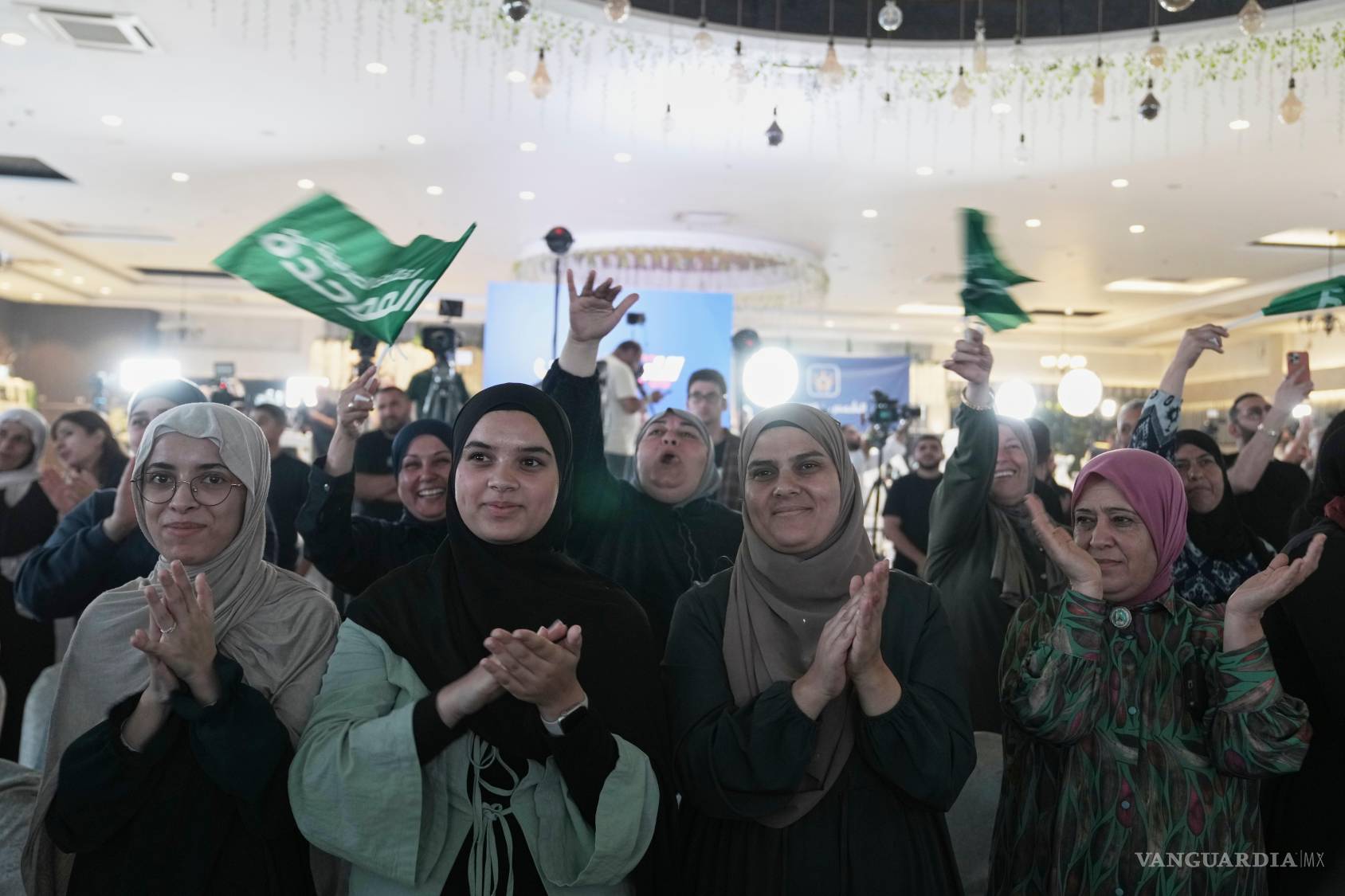 $!Partidarios del partido Raam, del legislador israelí Mansour Abbas, aplauden y ondean banderas tras la publicación de los primeros sondeos de las elecciones.