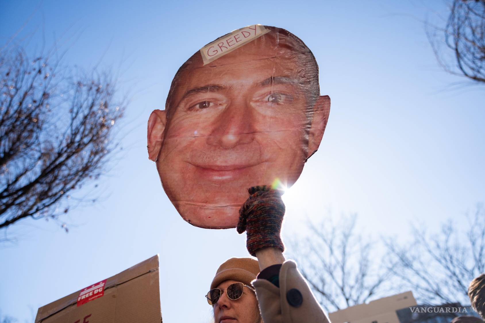 $!Un manifestante sostiene un recorte de la cara de Jeff Bezos afuera de la oficina del Washington Post luego de un despido masivo en Washington.