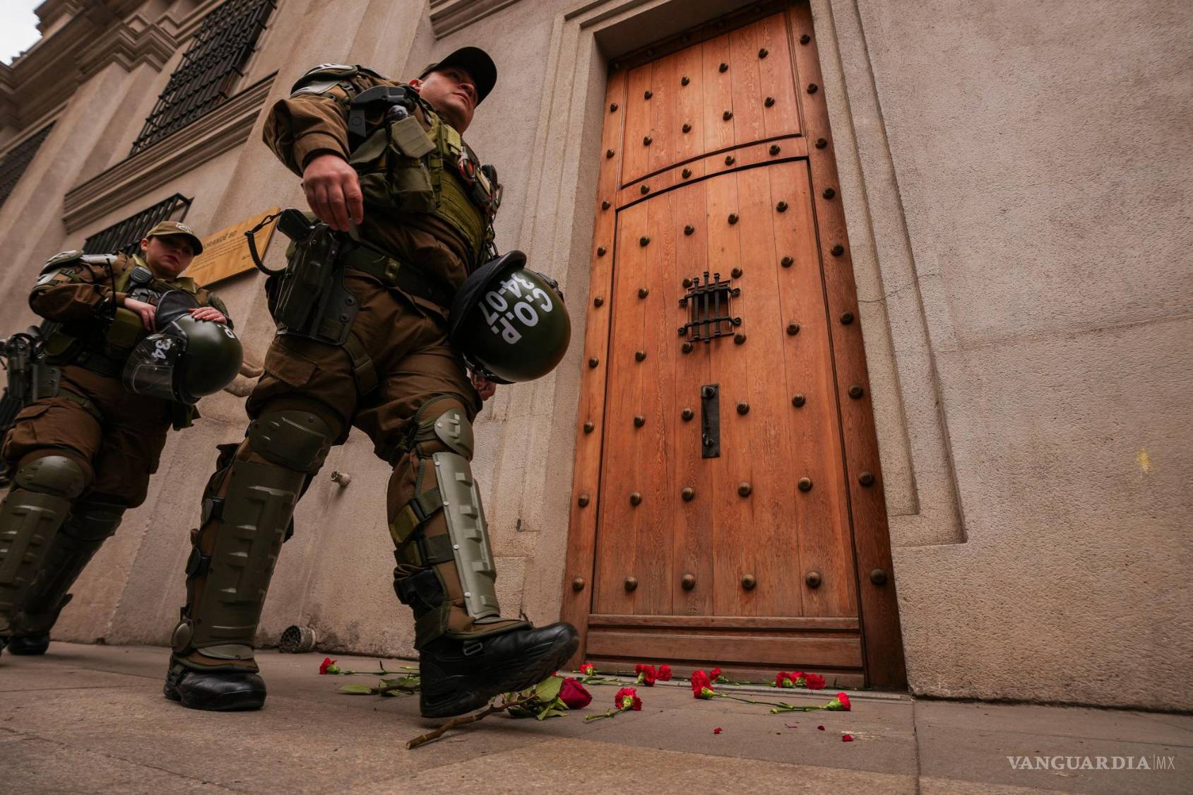 $!Policías pasan junto a las flores depositadas frente a la entrada este del Palacio de La Moneda, sede de la presidencia, en el aniversario del golpe militar de 1973 en Santiago de Chile, el viernes 11 de septiembre de 2026. (AP Foto/Esteban Félix)