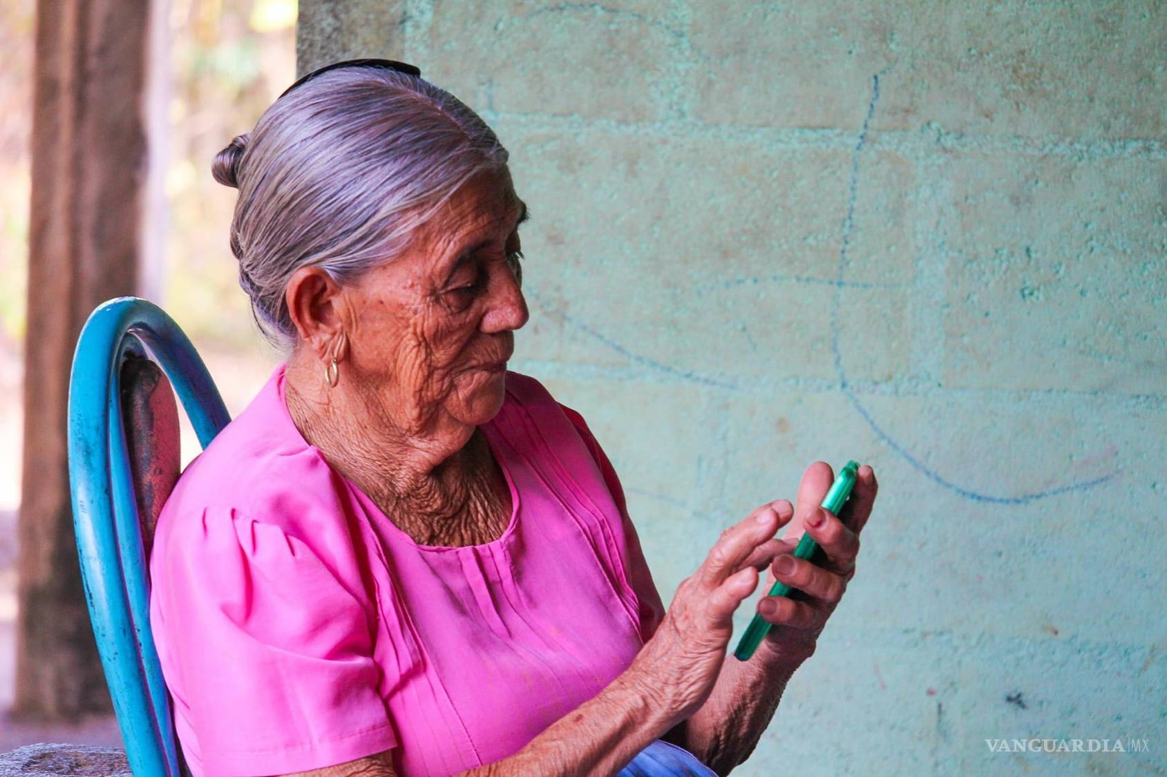 $!Bernaldina Bonilla de 83 años de edad, descansa en su casa en una zona rural del oriente salvadoreño mientras trata de utilizar un teléfono inteligente.