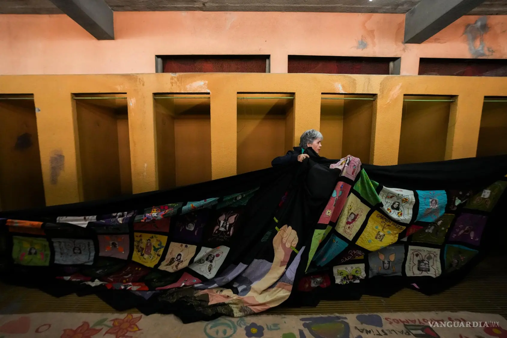$!Una mujer ayuda a colgar una pancarta de homenaje en el vestuario femenino del Estadio Nacional —utilizado como prisión y lugar de tortura durante el golpe de Estado orquestado por el general Augusto Pinochet— en Santiago de Chile, el viernes 11 de septiembre de 2026.