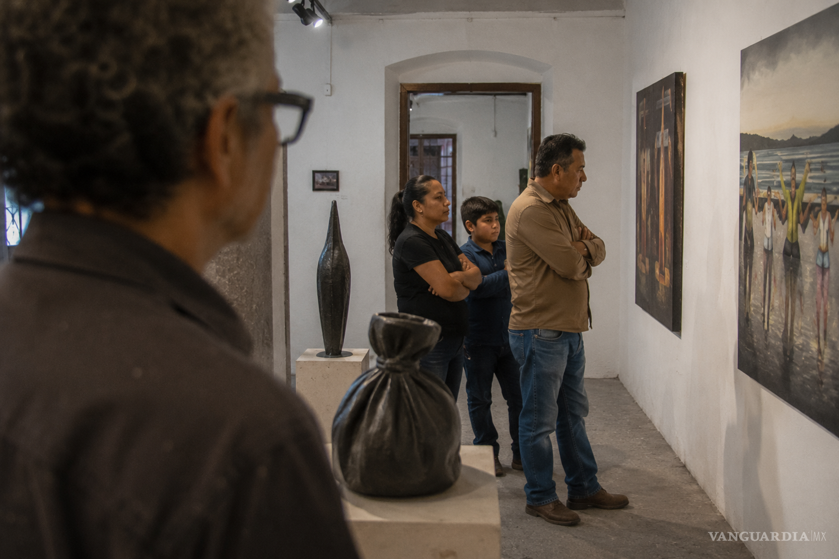 $!El vecino y su familia recorren una exposición sin acercarse al artista que vive frente a su casa. La entrada al espacio público de su obra no modifica la distancia que ambos habían mantenido en la calle.