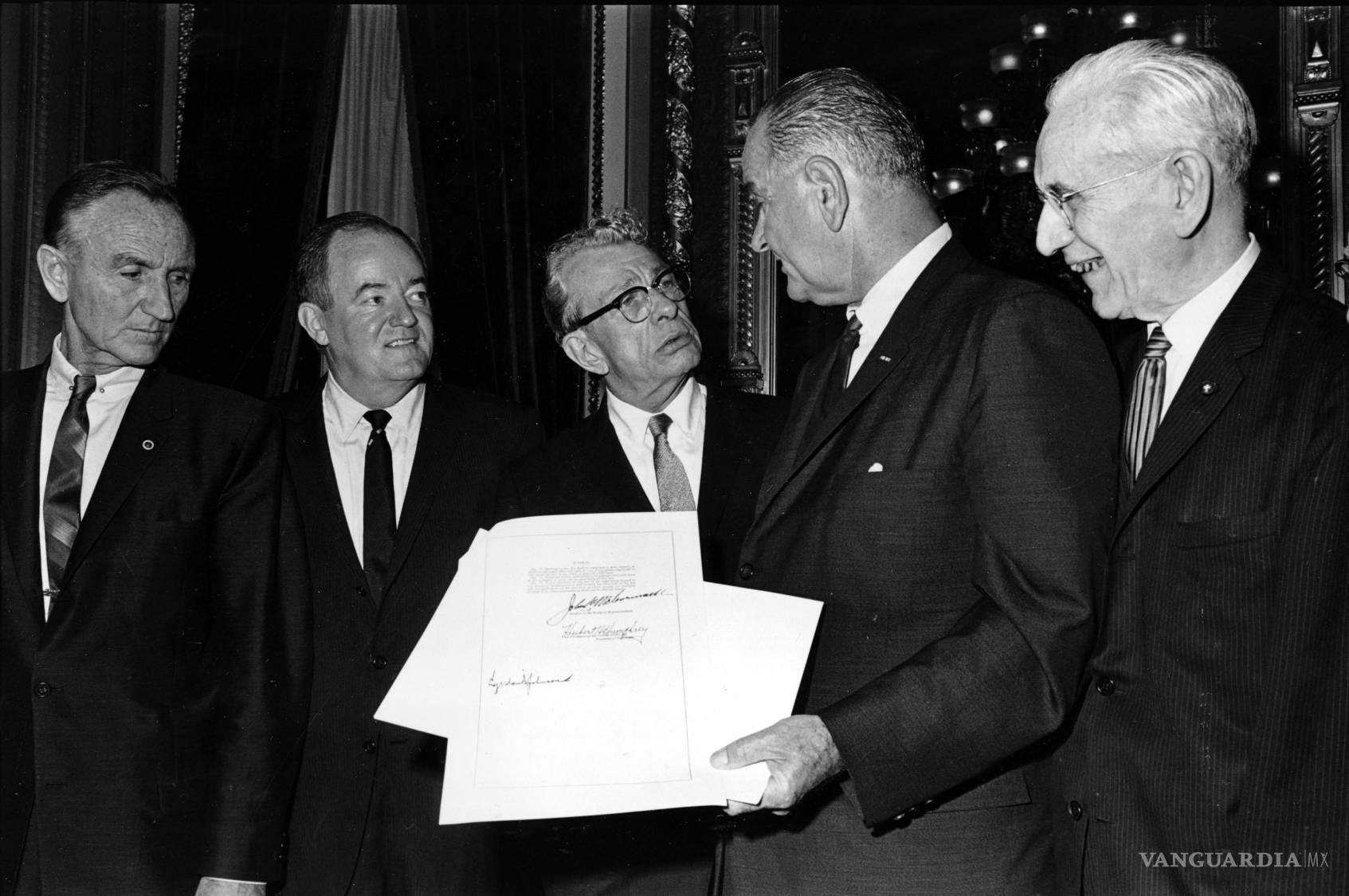 $!El presidente de Estados Unidos Lyndon B. Johnson, sostiene el documento firmado que sanciona la Ley de Derecho al Voto de 1965.