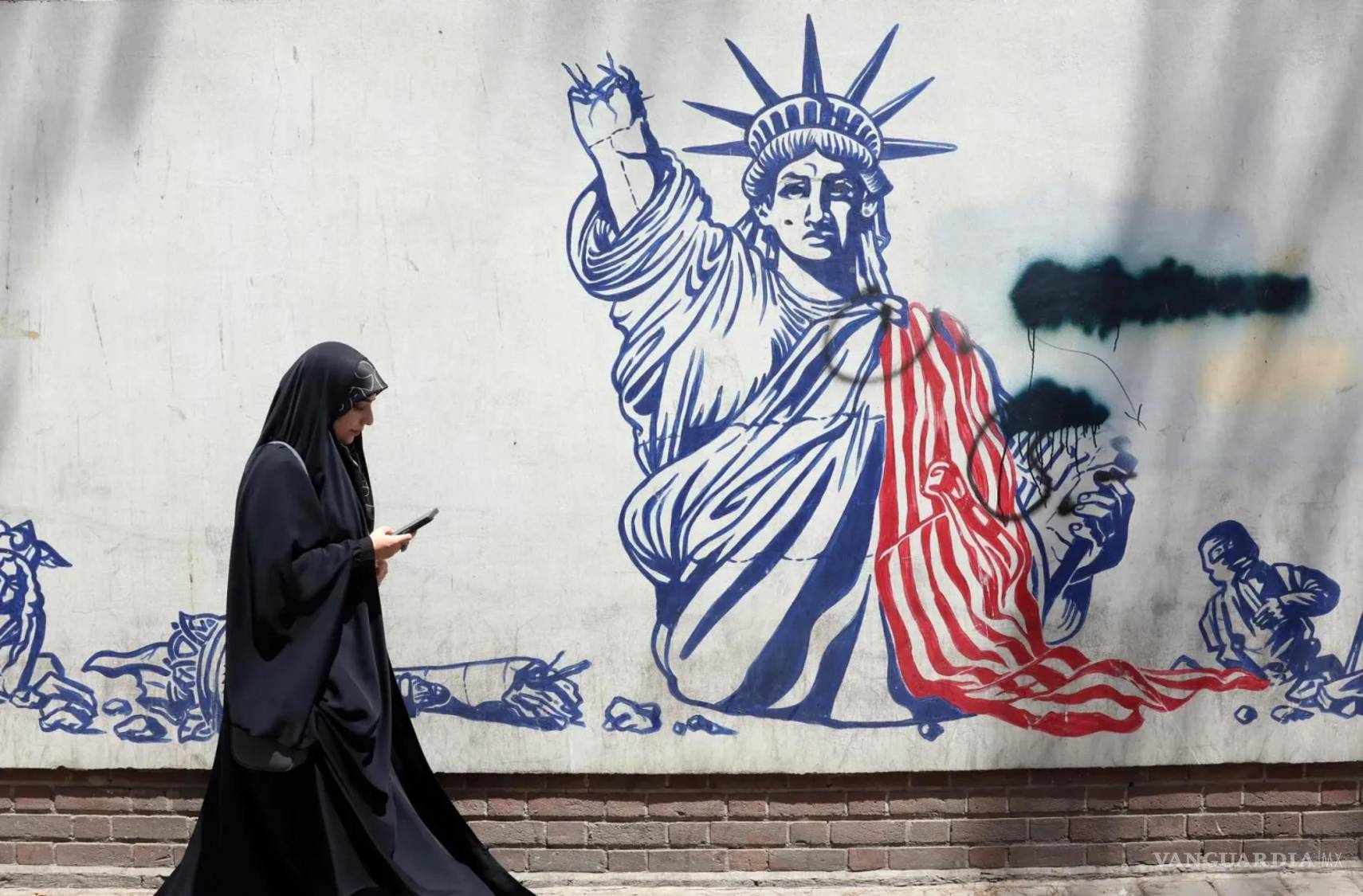 $!Una mujer pasa junto a un mural antiestadounidense cerca de la antigua embajada de Estados Unidos en Teherán, Irán. EFE/ABEDIN