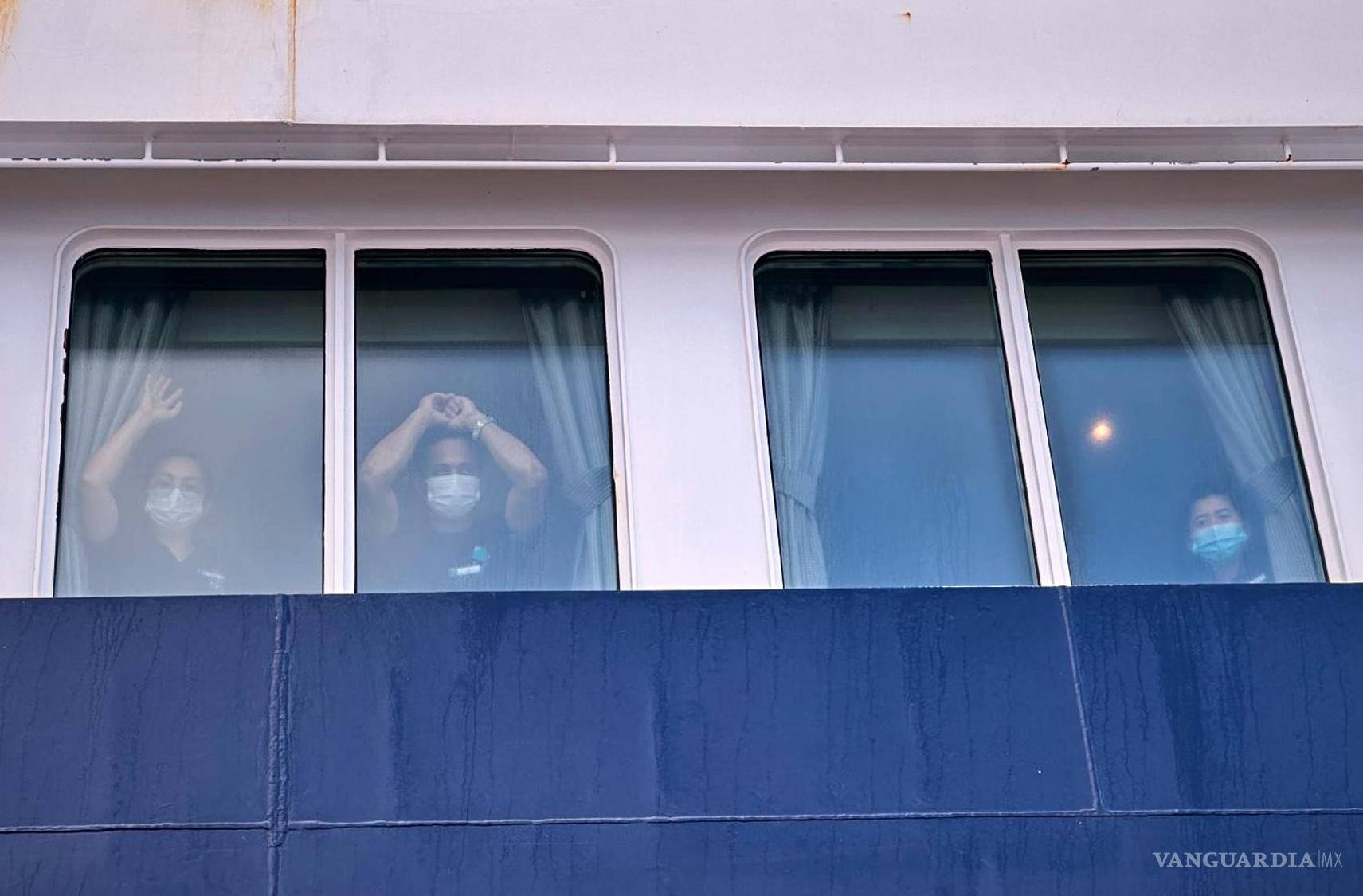 $!Los pasajeros observan cómo otros desembarcan del crucero MV Hondius, afectado por el hantavirus, en el puerto de Granadilla, en Tenerife, Islas Canarias, España.