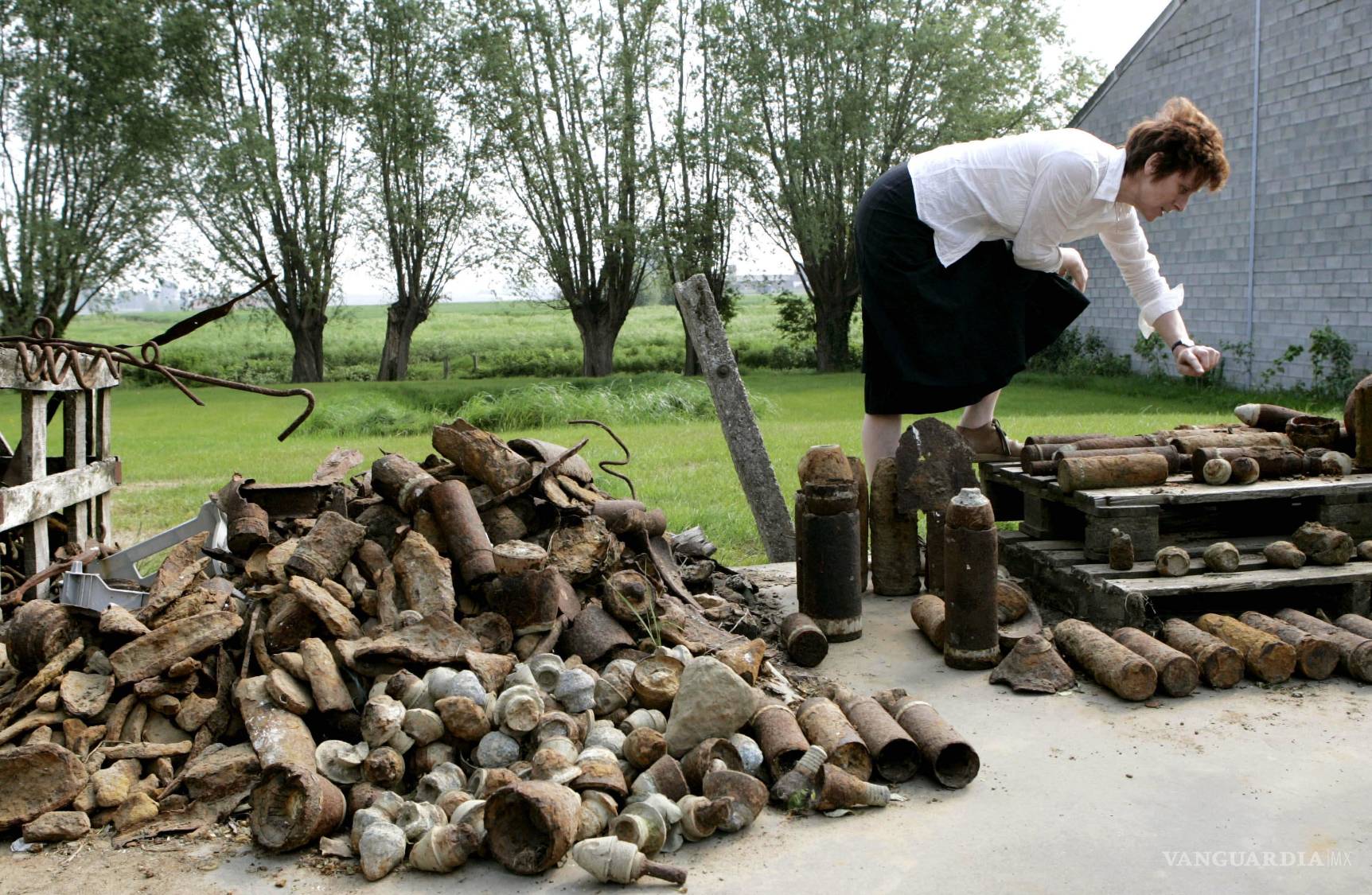 $!Charlotte Cardoen-Descamps señala distintos tipos de casquillos de proyectiles de la Primera Guerra Mundial encontrados en su granja en Poelkapelle, Bélgica, el 4 de mayo de 2007.