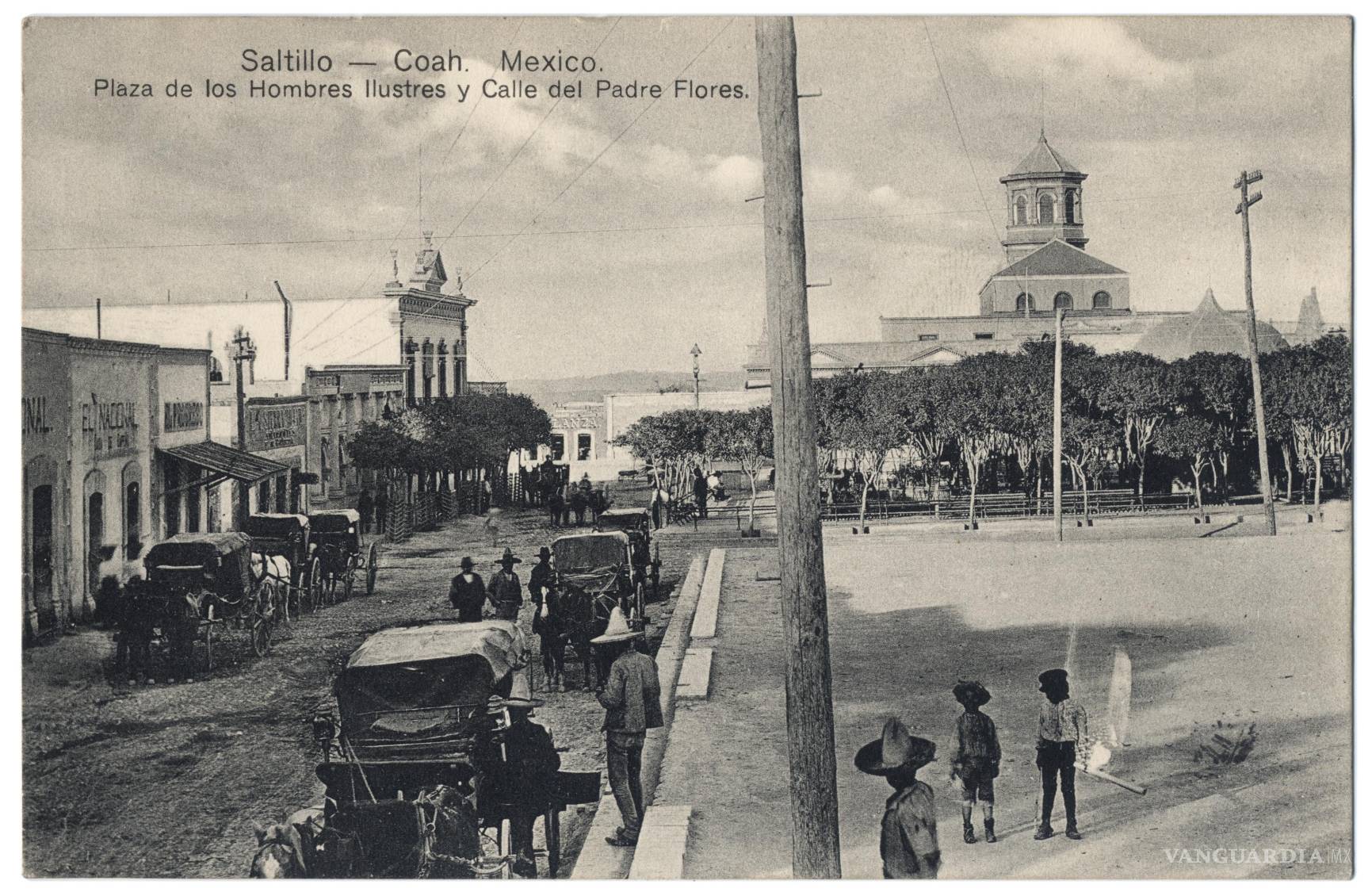$!Una postal de 1904 muestra la calle Padre Flores, con carruajes, postes de madera y tendidos aéreos que ya compartían espacio con la vida cotidiana de Saltillo. En el terreno de la Plaza de los Hombres Ilustres comenzaría, dos años después, la construcción del Teatro García Carrillo. La imagen conserva un momento en que distintas formas de movilidad, comunicación y arquitectura coexistían en una ciudad en transformación.