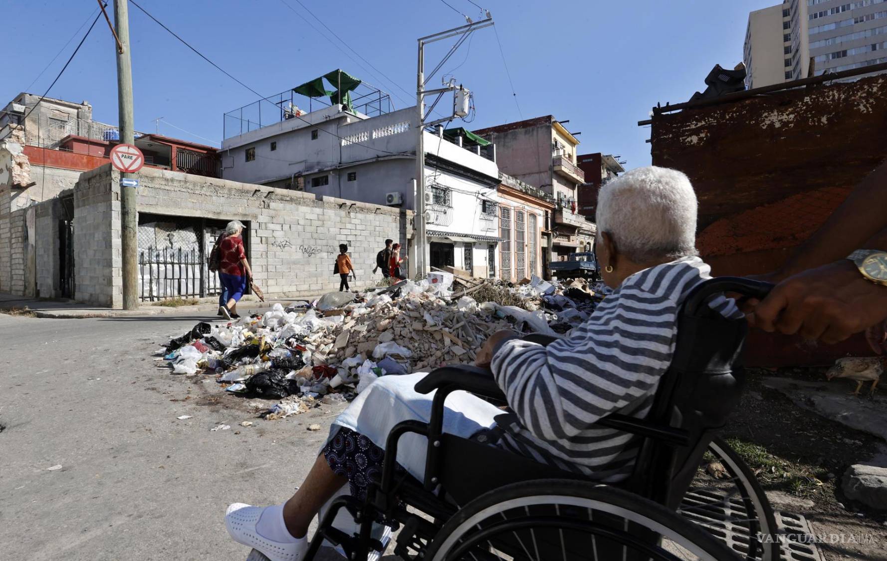 $!Un grupo de personas camina por una calle con basura, en La Habana, Cuba.